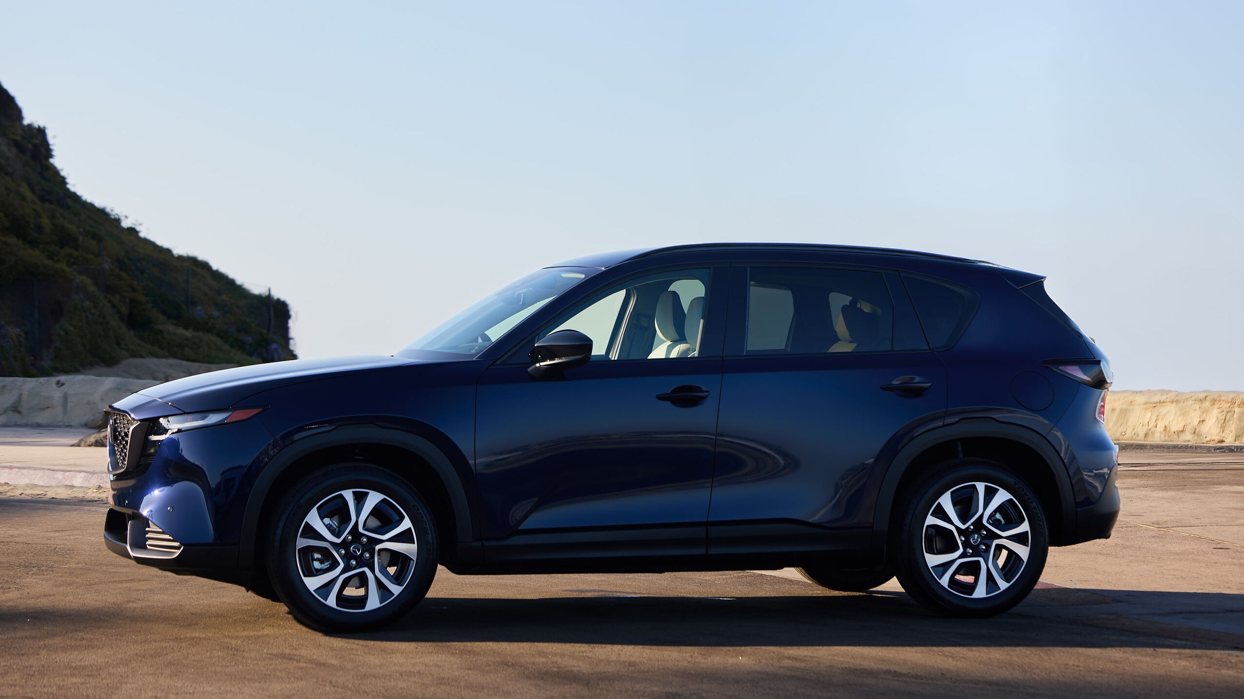 2026 Mazda CX-5 in dark blue, side profile, parked near a coastal cliff