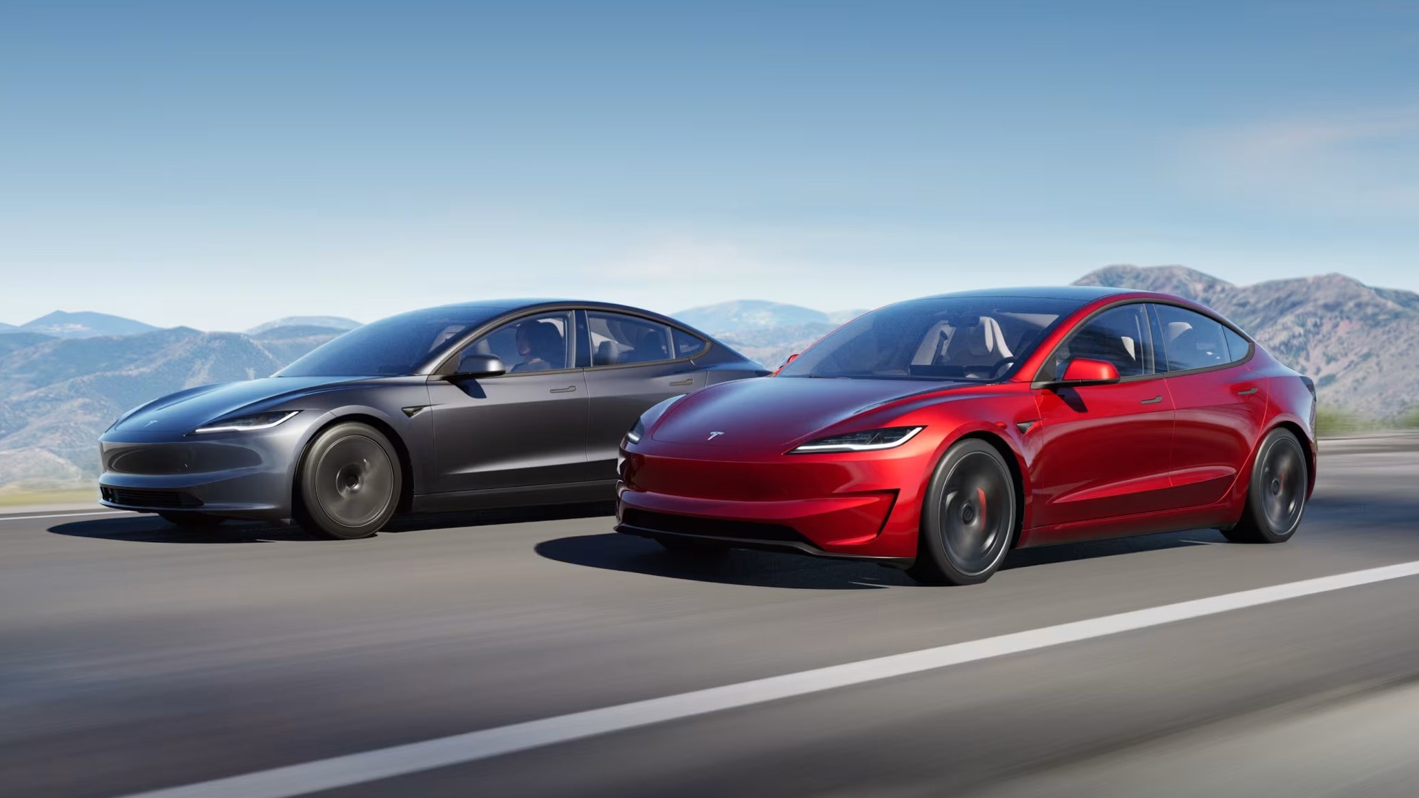 Two Tesla Model 3 sedans driving on a mountain road