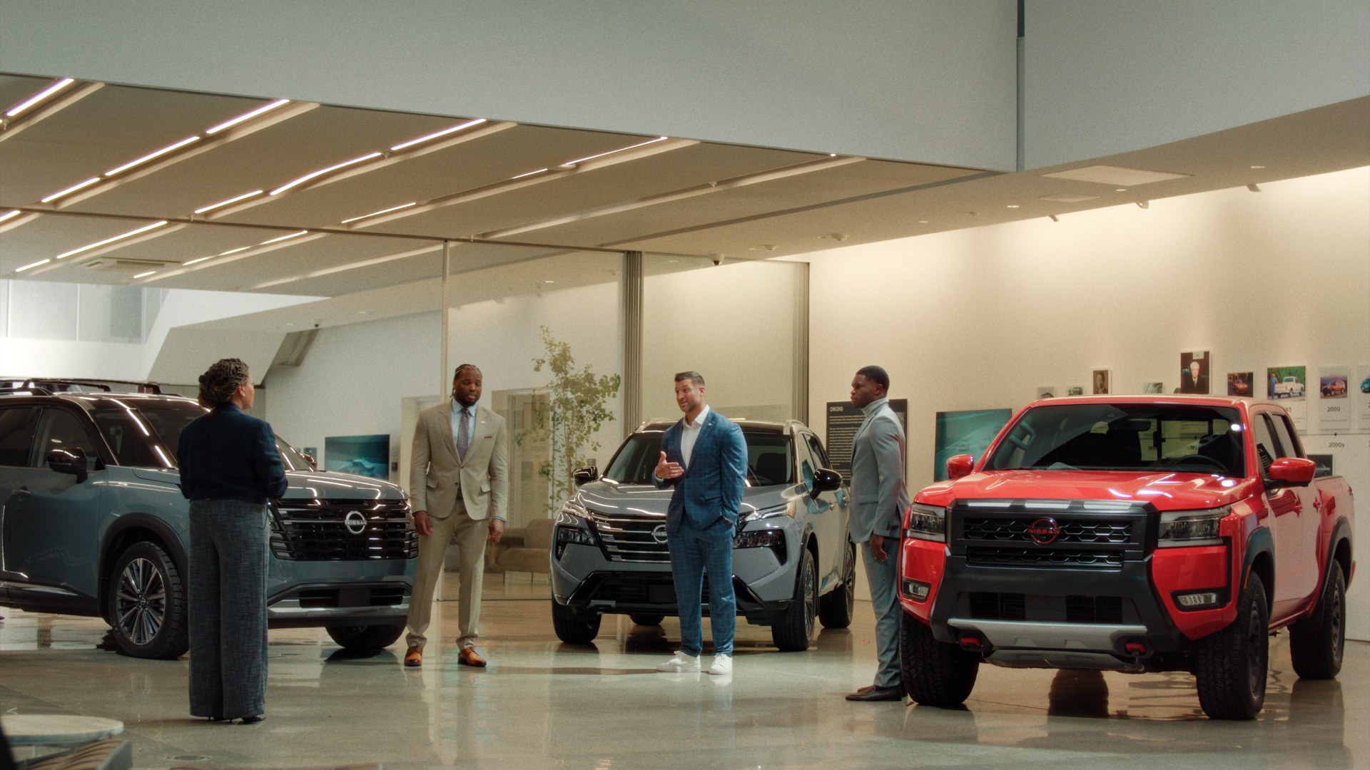 Heisman Trophy winners stand among Nissan Pathfinder, Rogue and Frontier PRO-4X in a showroom scene from the 2026 campaign