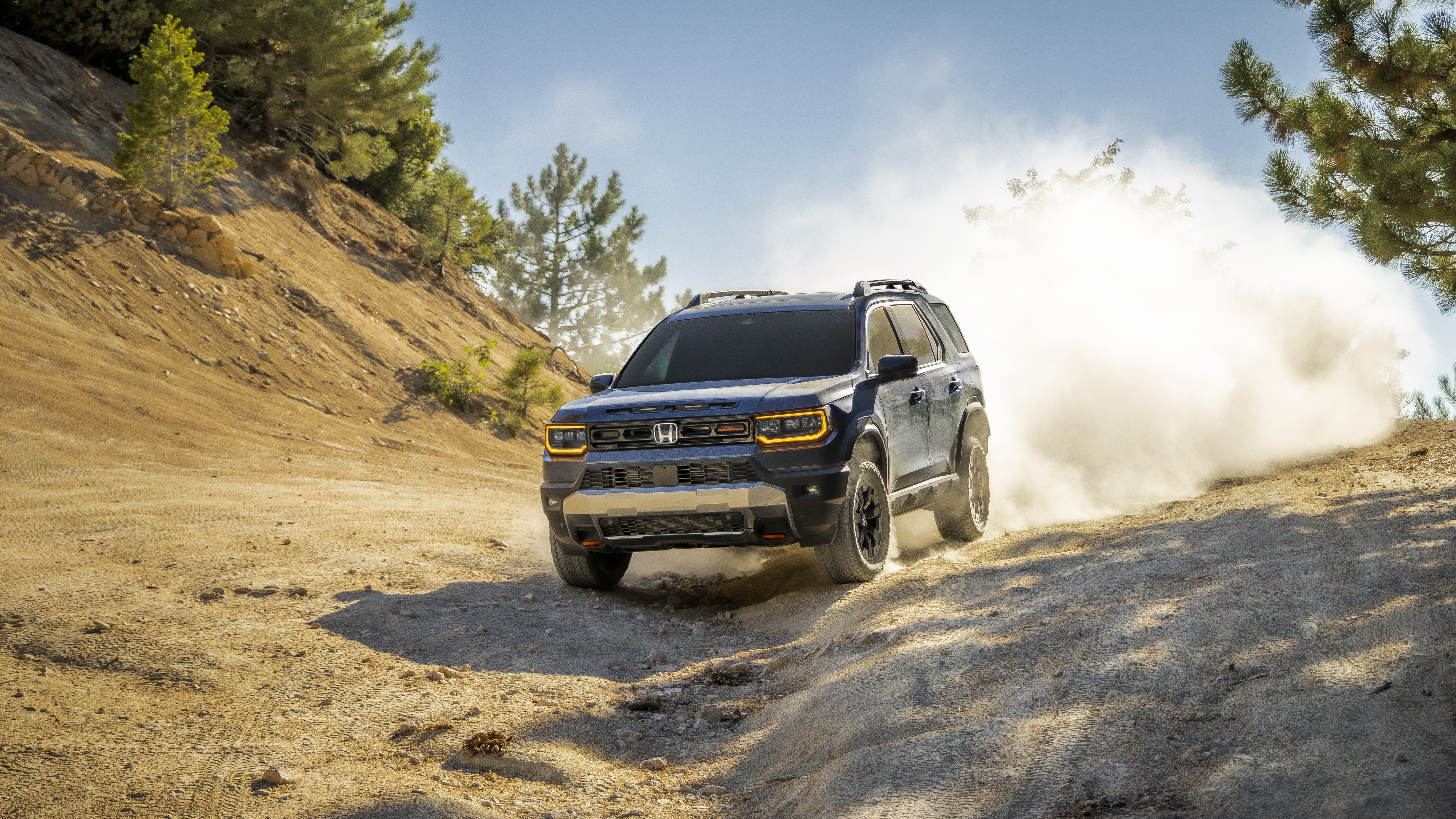 2027 Honda Passport TrailSport driving down a dusty dirt trail, front three-quarter view