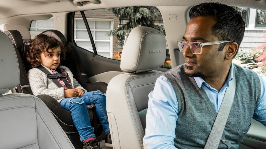 Driver looking back at toddler secured in a child car seat