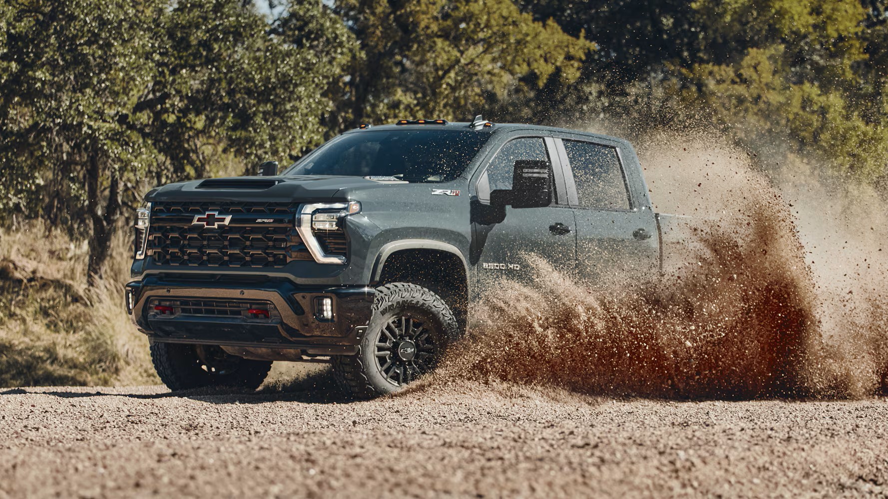 Chevrolet Silverado 2500 HD ZR2 kicking up dirt on a gravel trail