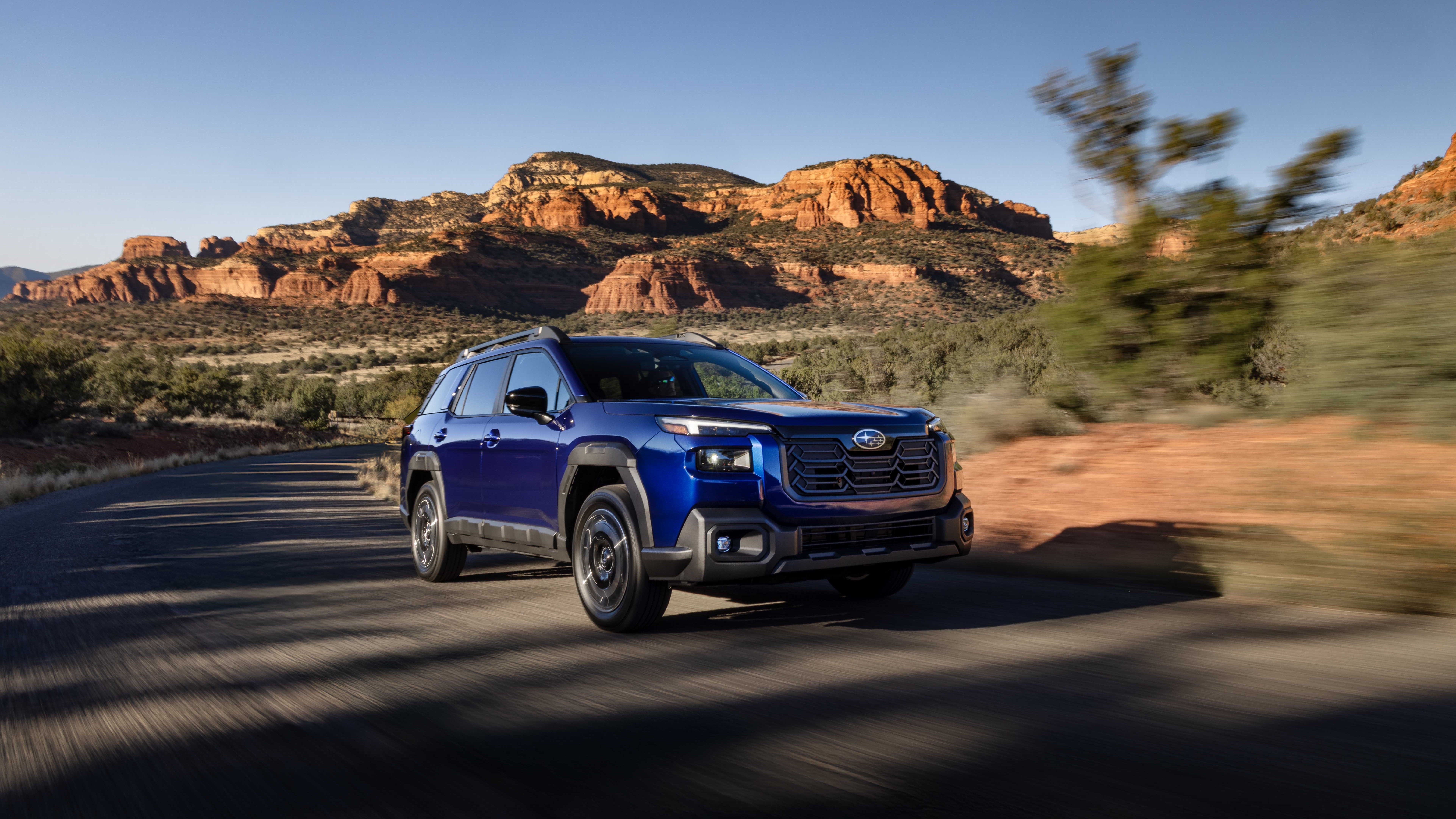 2026 Subaru Outback driving on a desert road, front three-quarter view