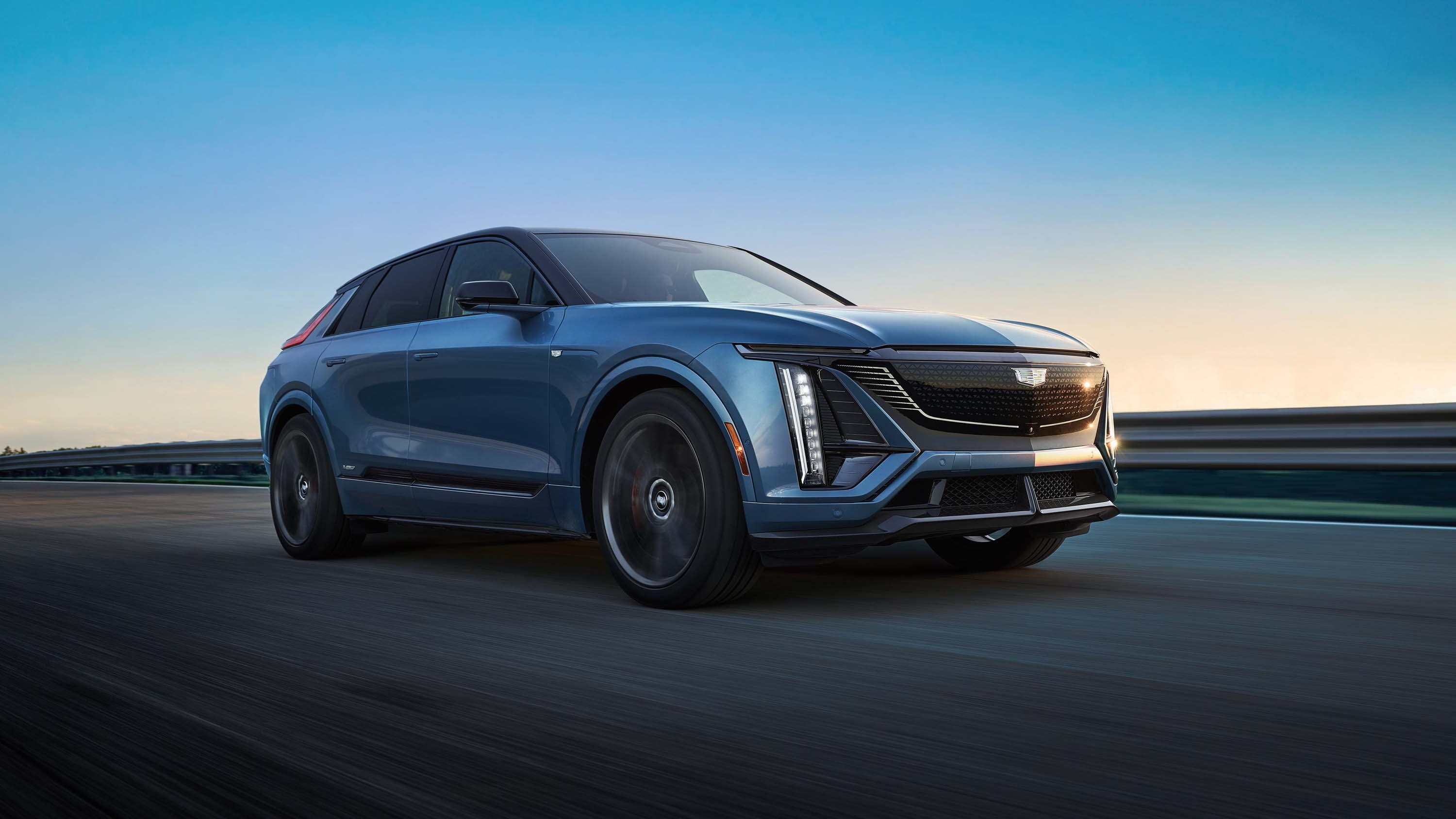 2027 Cadillac Lyriq-V electric SUV driving on a track at dusk
