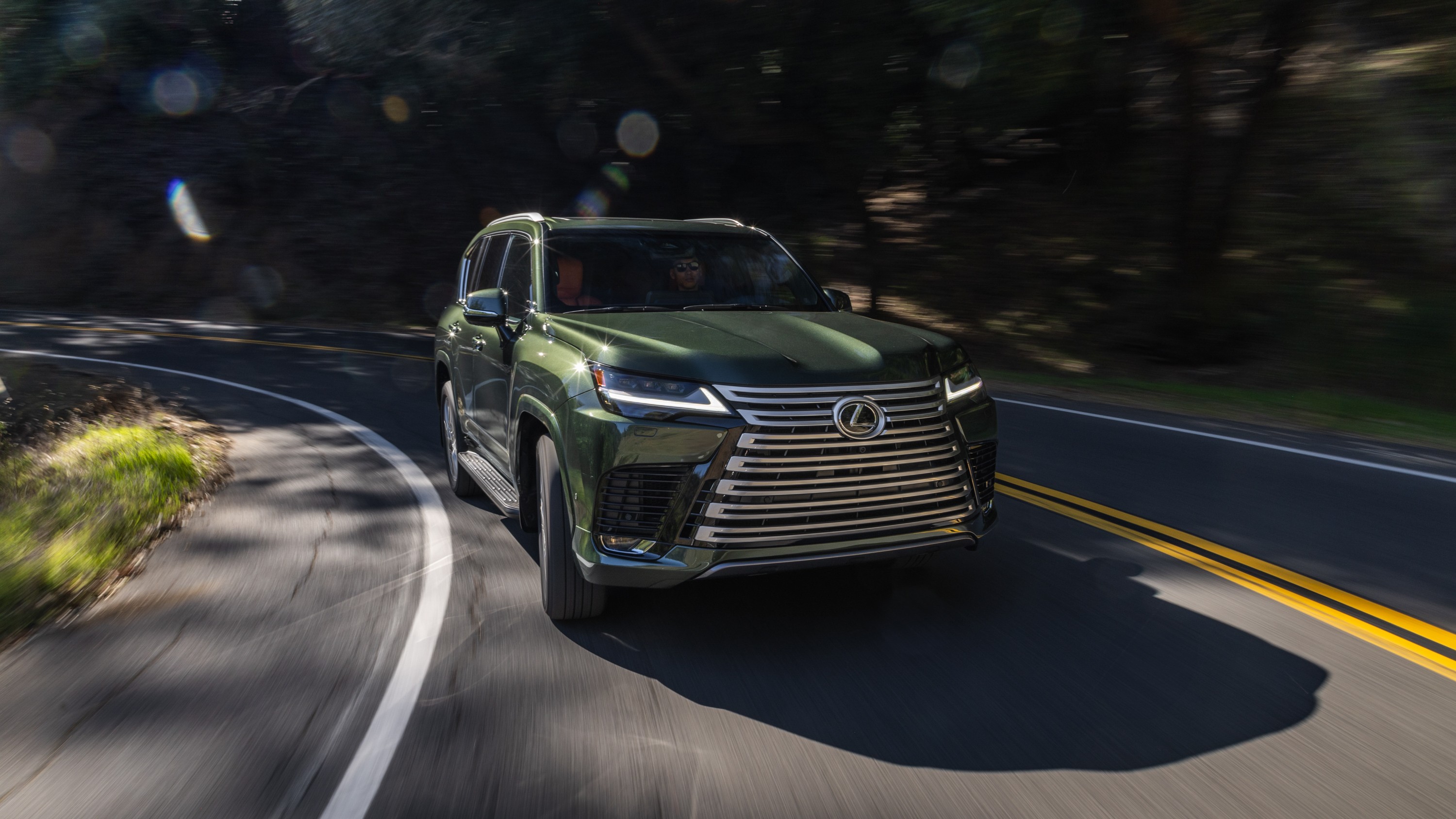 2027 Lexus LX 700h Ultra Luxury in Nori Green Pearl driving on a road