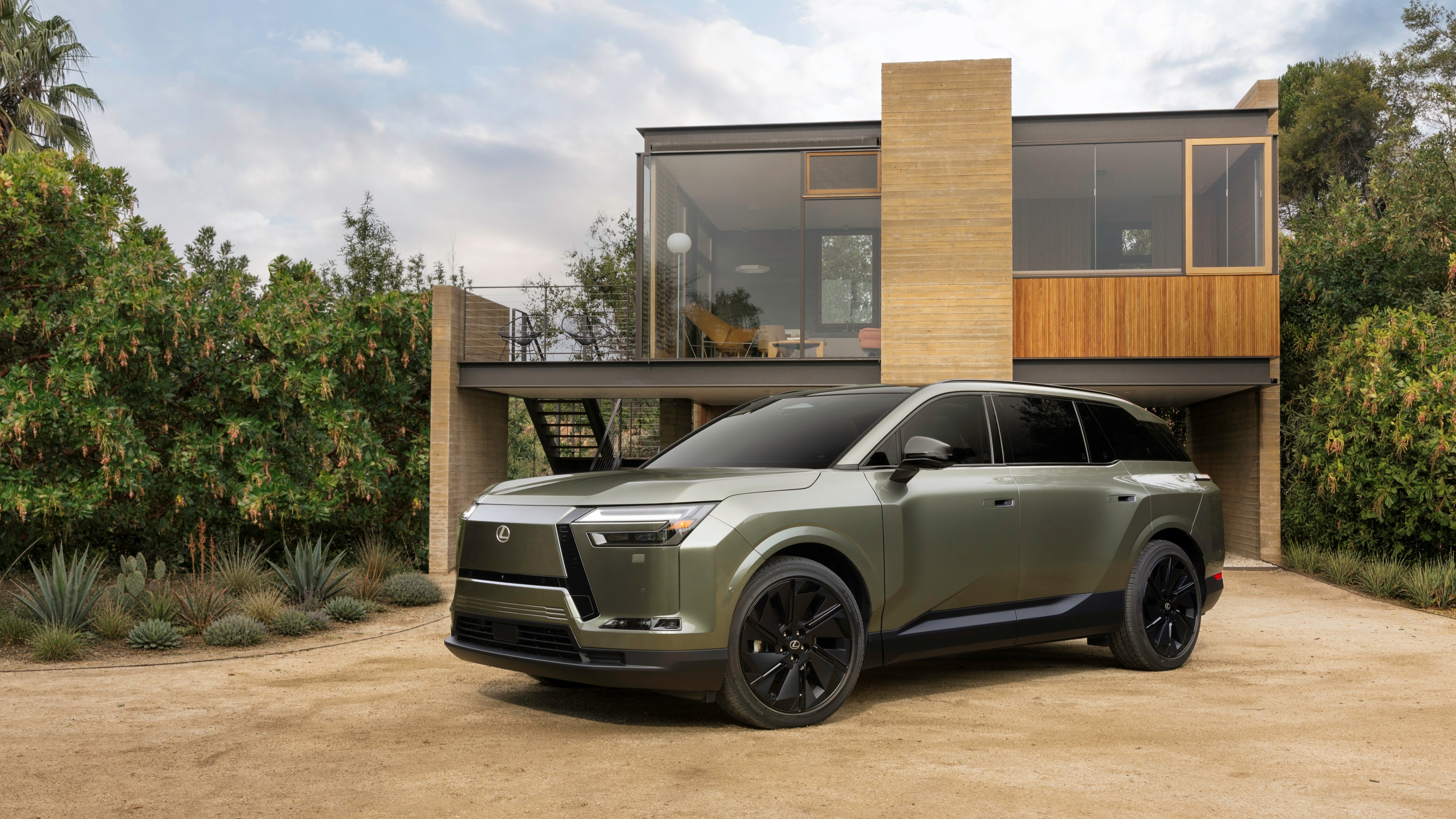 2027 Lexus TZ electric SUV parked in front of a modern house