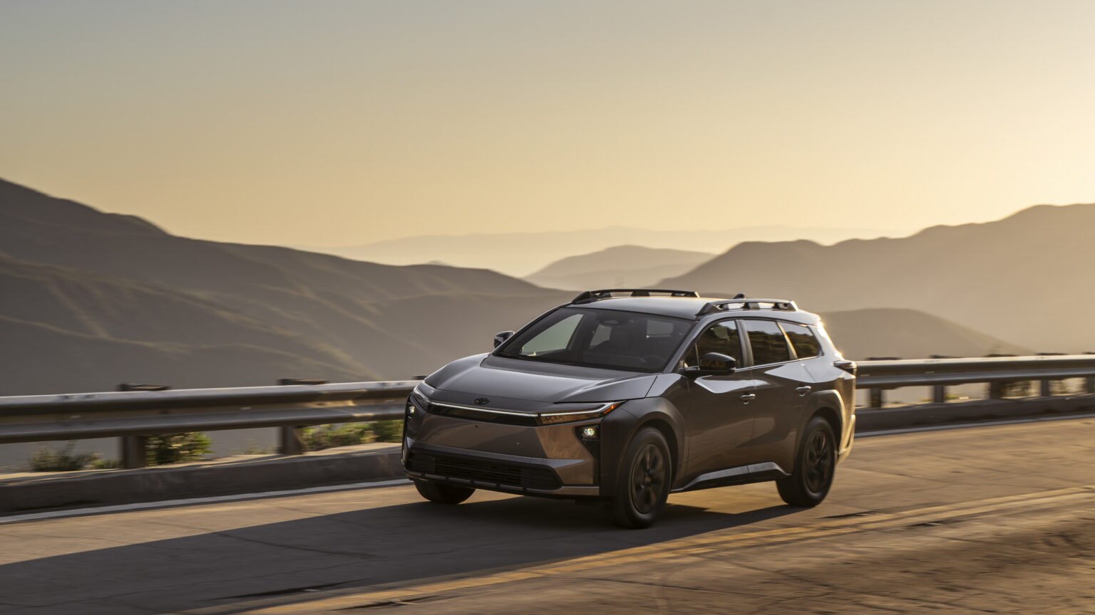 2027 Toyota bZ Woodland Premium driving on a mountain road at dusk