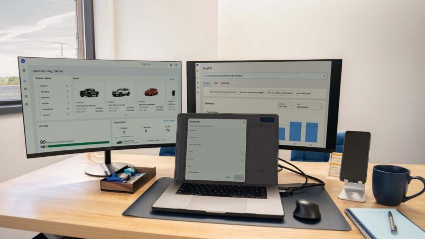GM OnStar Fleet Intelligence dashboard on two monitors and a laptop