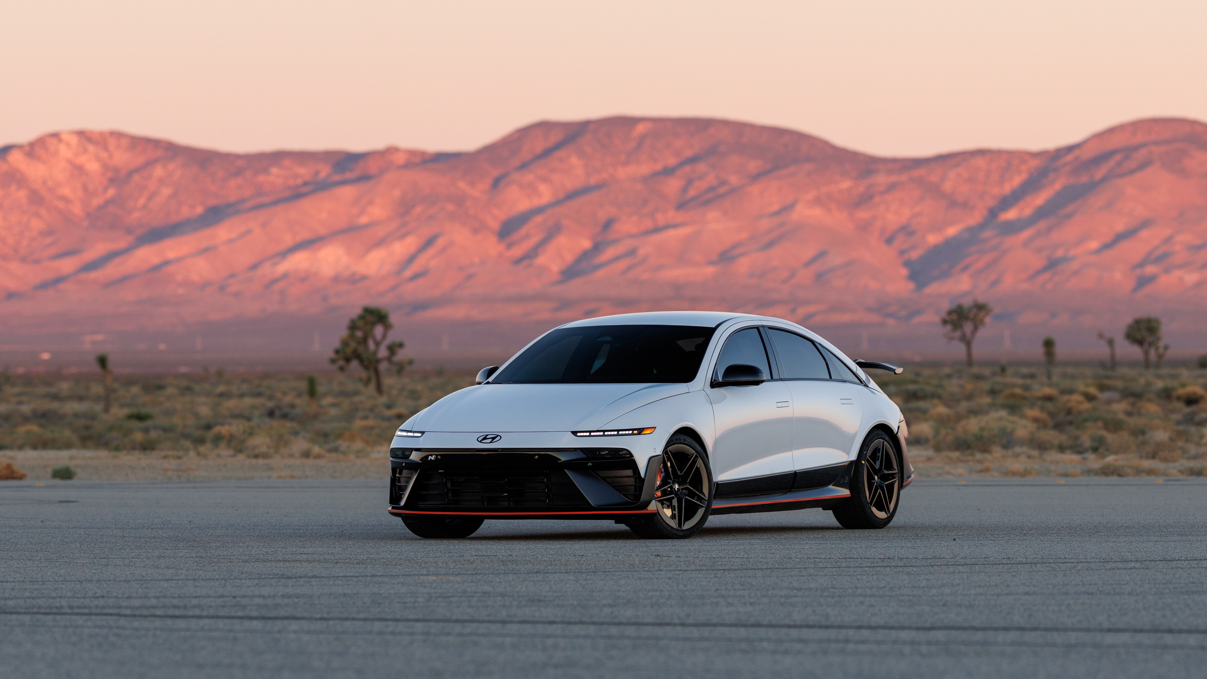 White Hyundai Ioniq 6 N sedan parked in the desert at sunset
