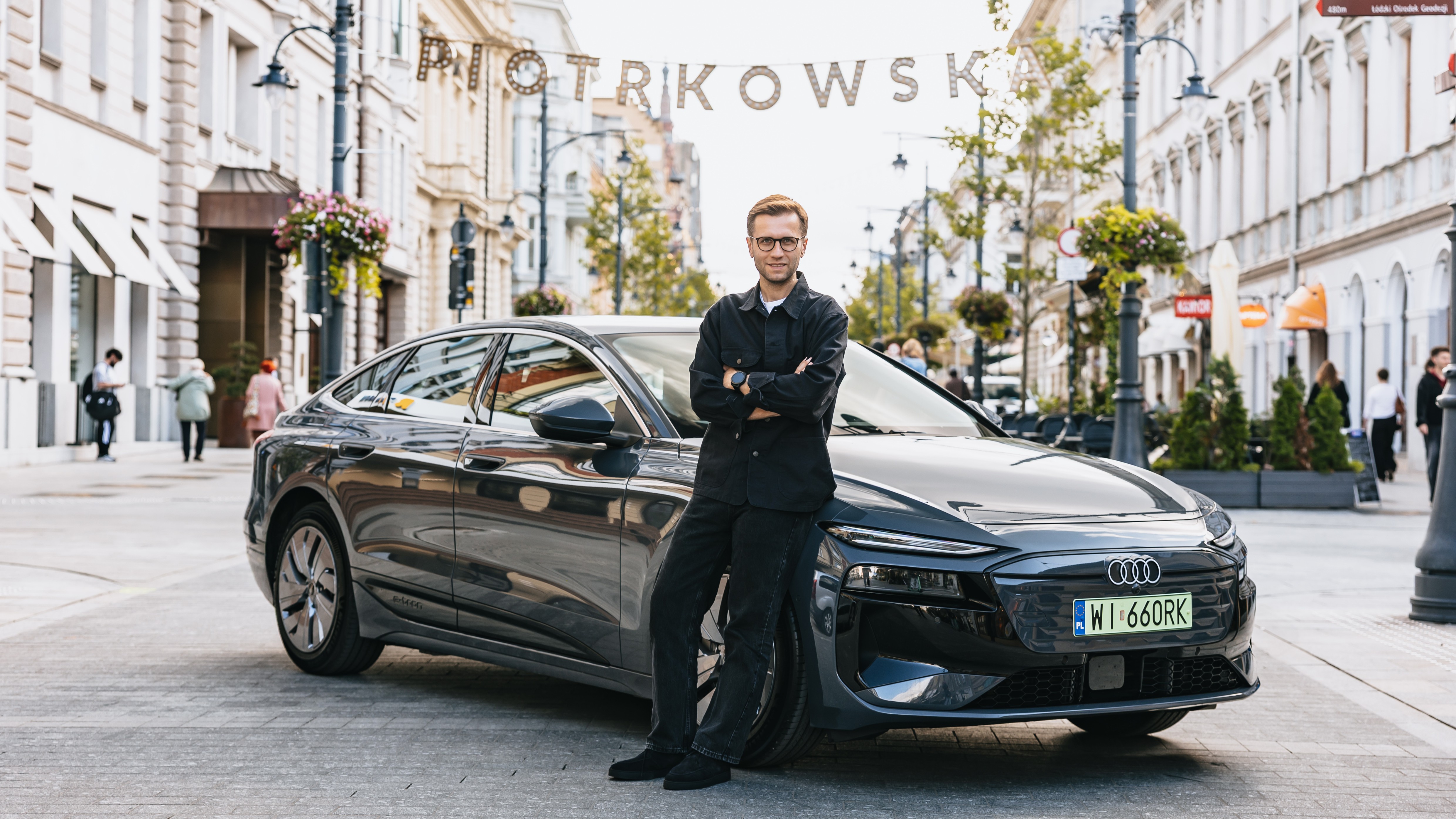 Miko Marczyk leaning on a gray Audi A6 Sportback e-tron in Łódź