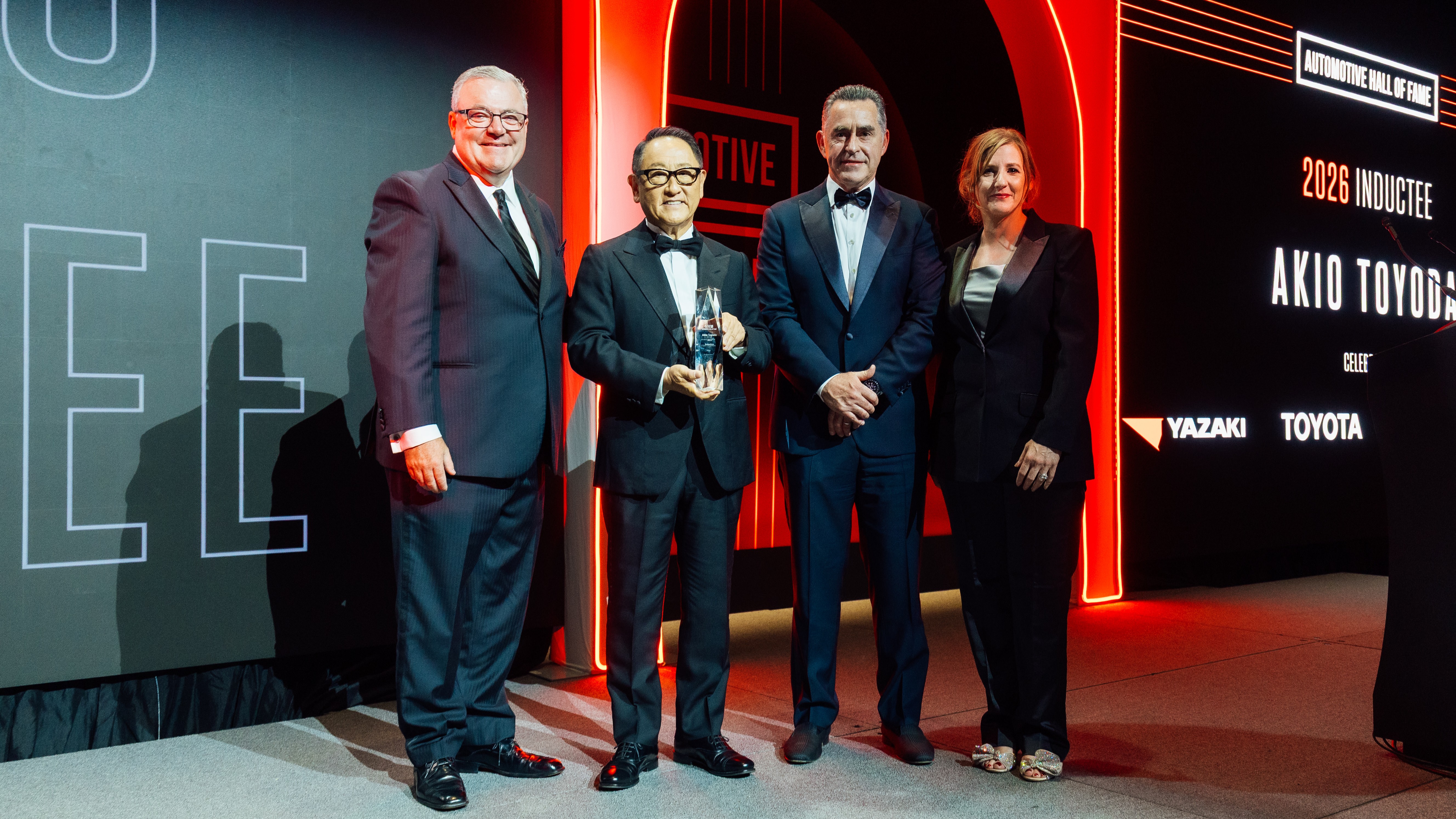 Akio Toyoda holds his Automotive Hall of Fame award on stage in Detroit