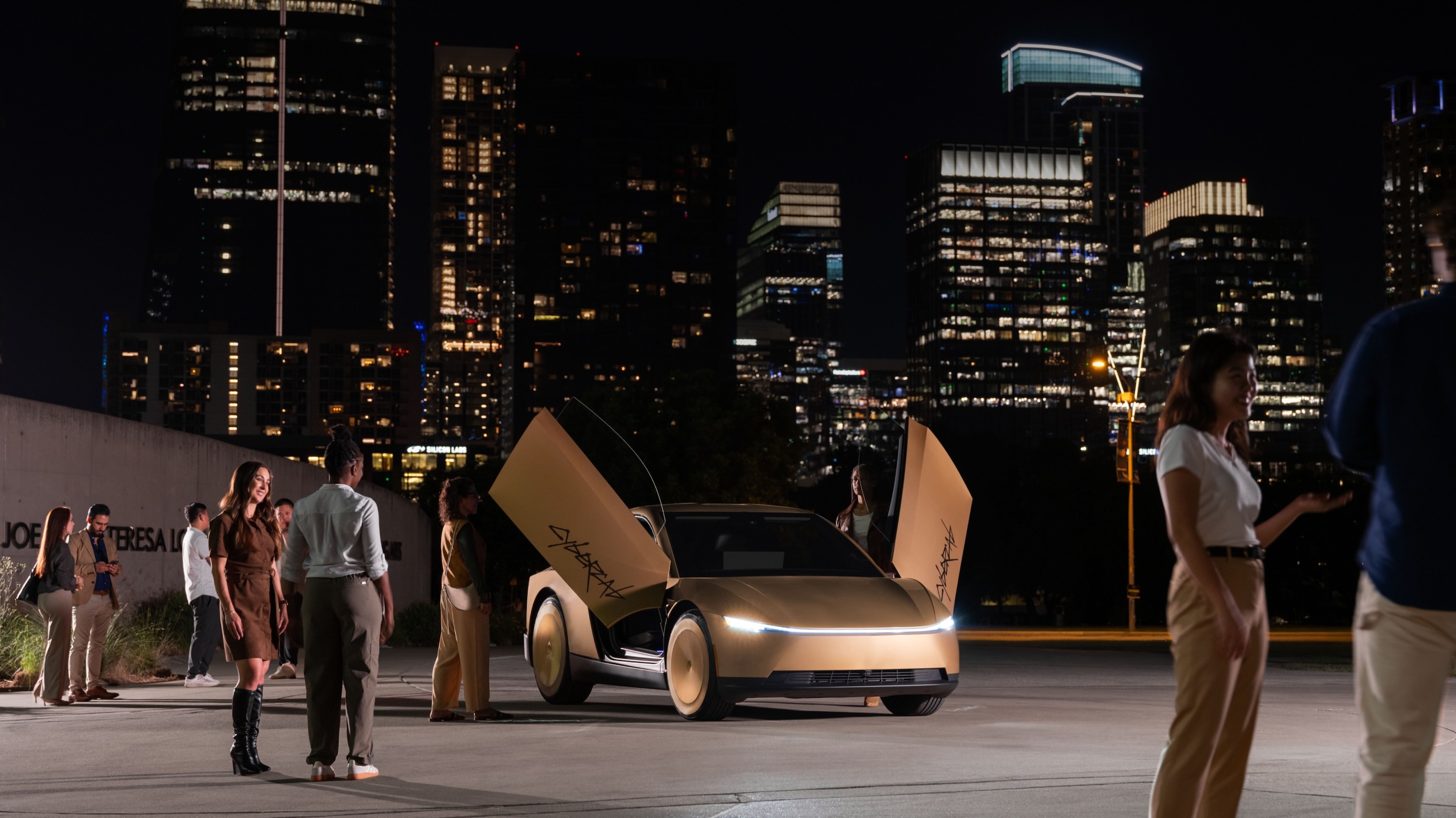 Gold Tesla Cybercab with butterfly doors open in downtown Austin at night