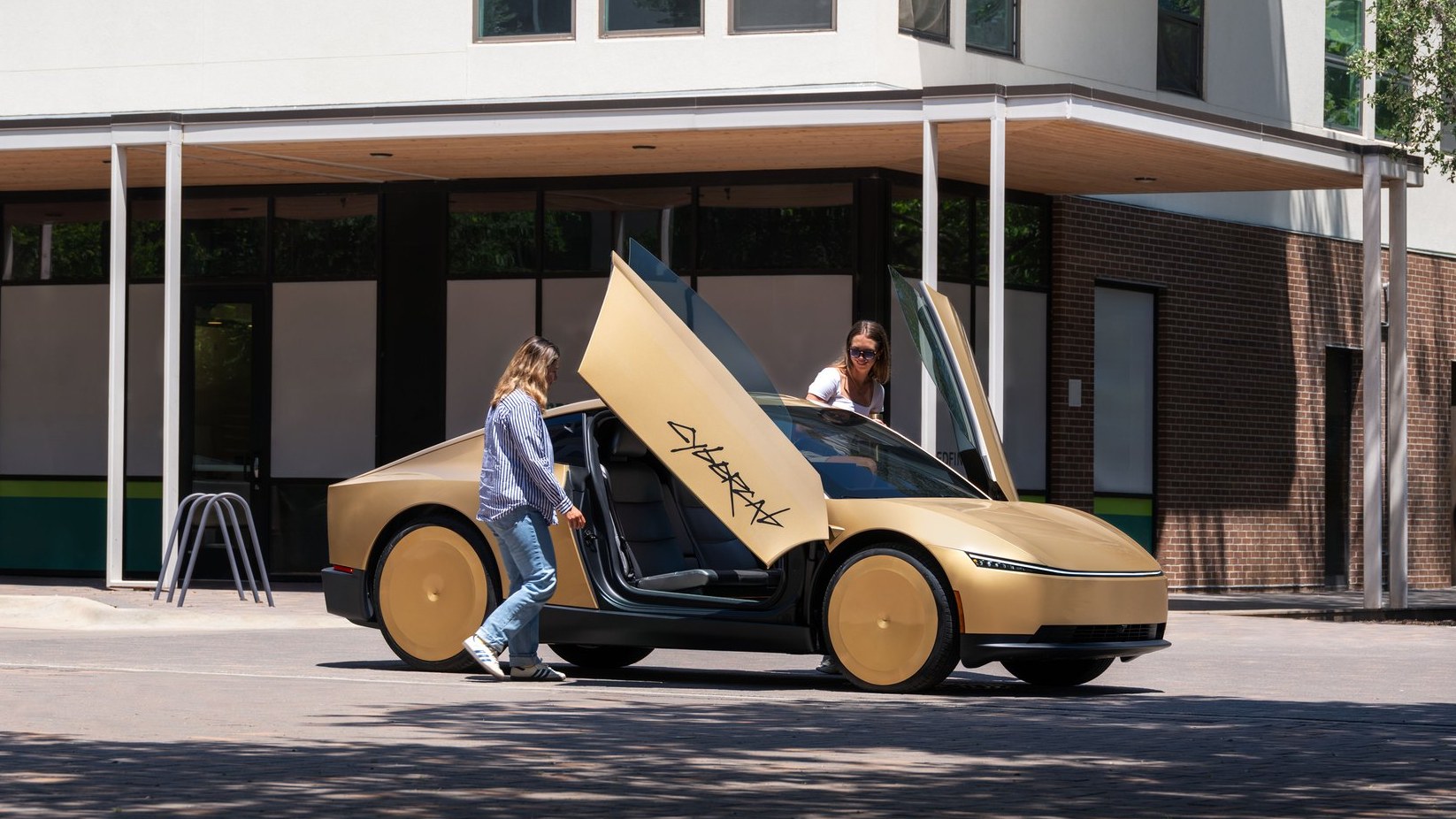 Passenger stepping into a gold Tesla Cybercab with its butterfly door open