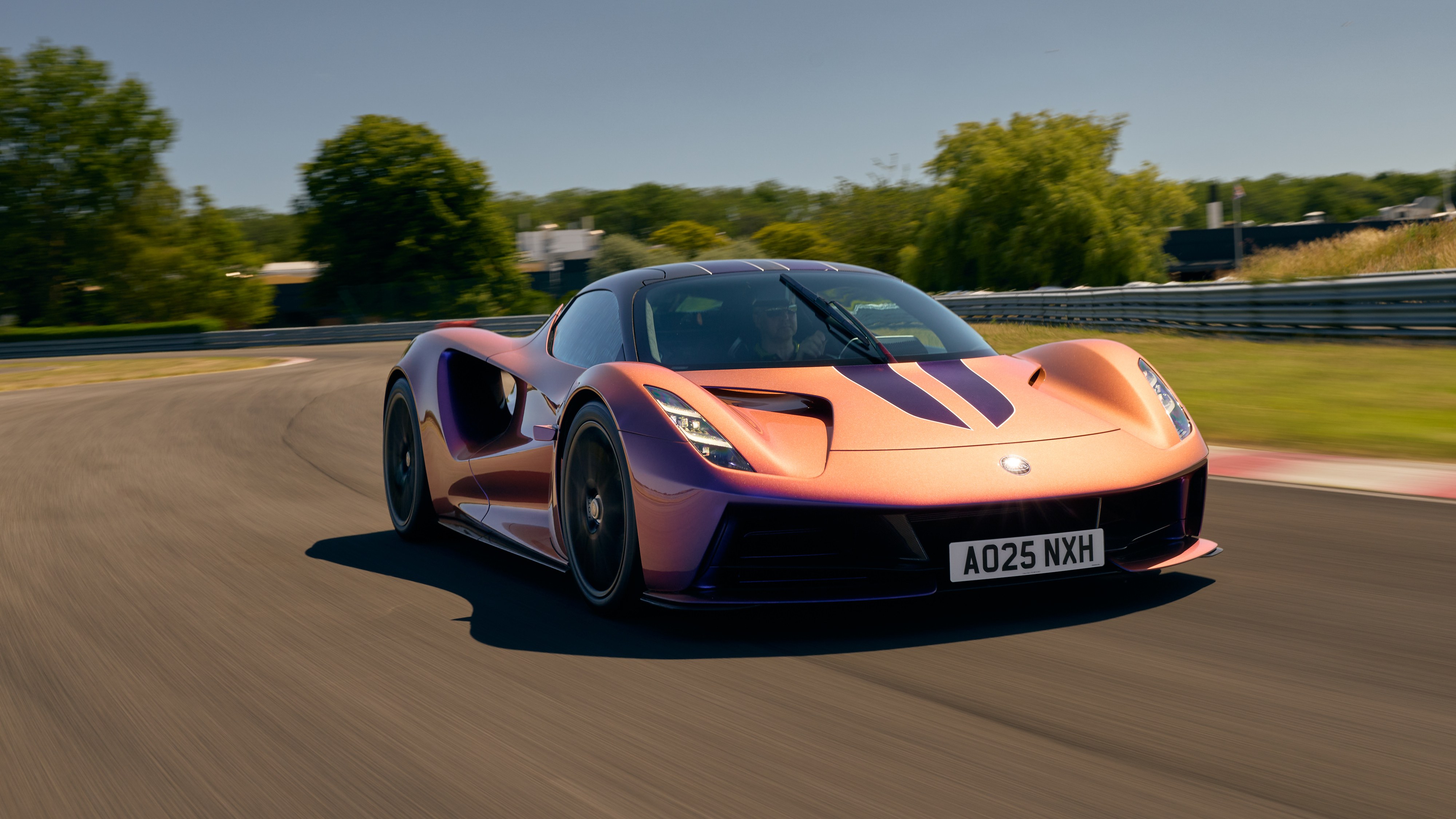 Lotus Evija electric hypercar driving on a track, front three-quarter view