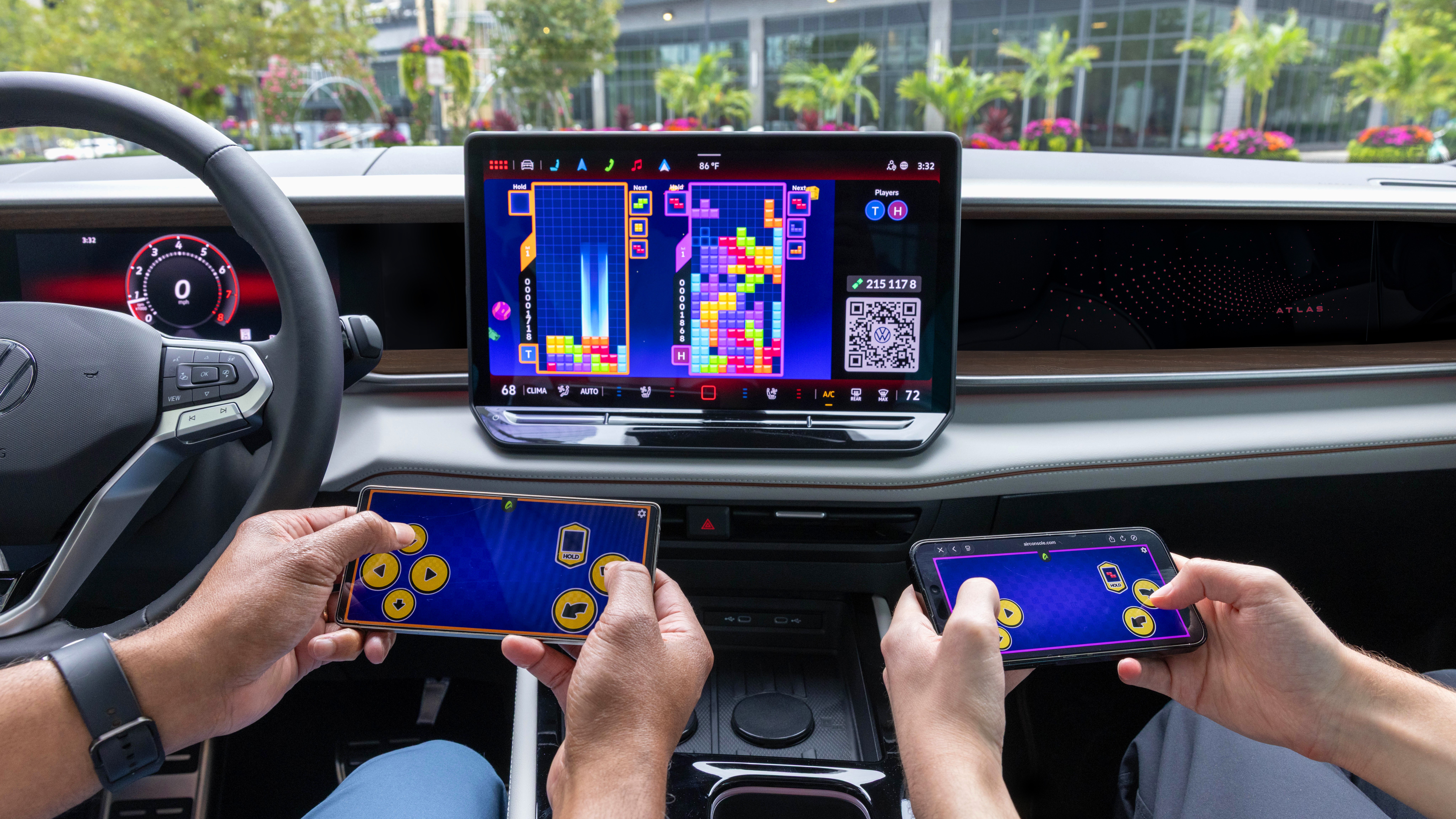 Two occupants play Tetris on a 2027 VW Atlas screen using phones