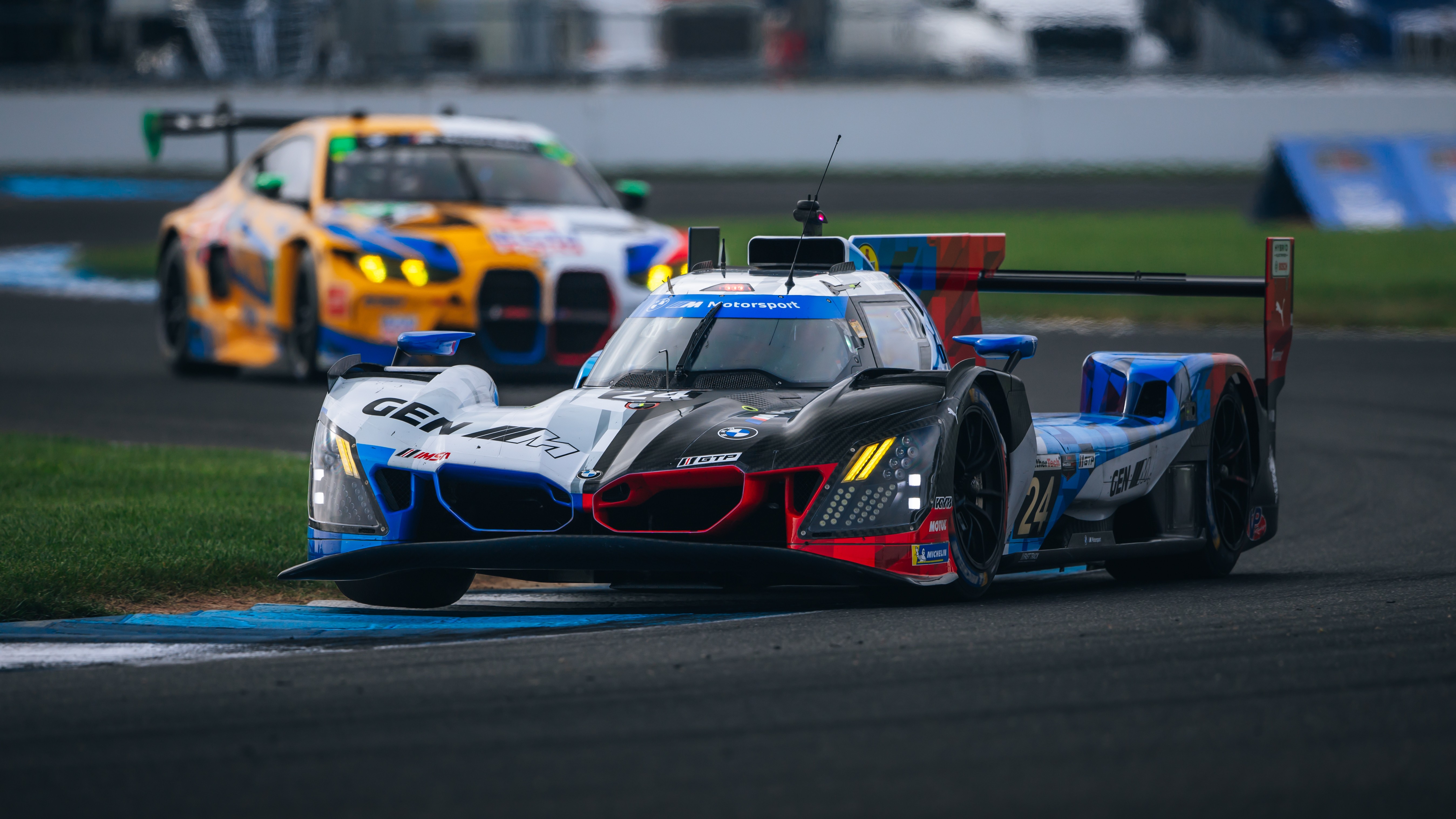 No. 24 BMW M Hybrid V8 cornering ahead of a BMW M4 GT3 at Indianapolis