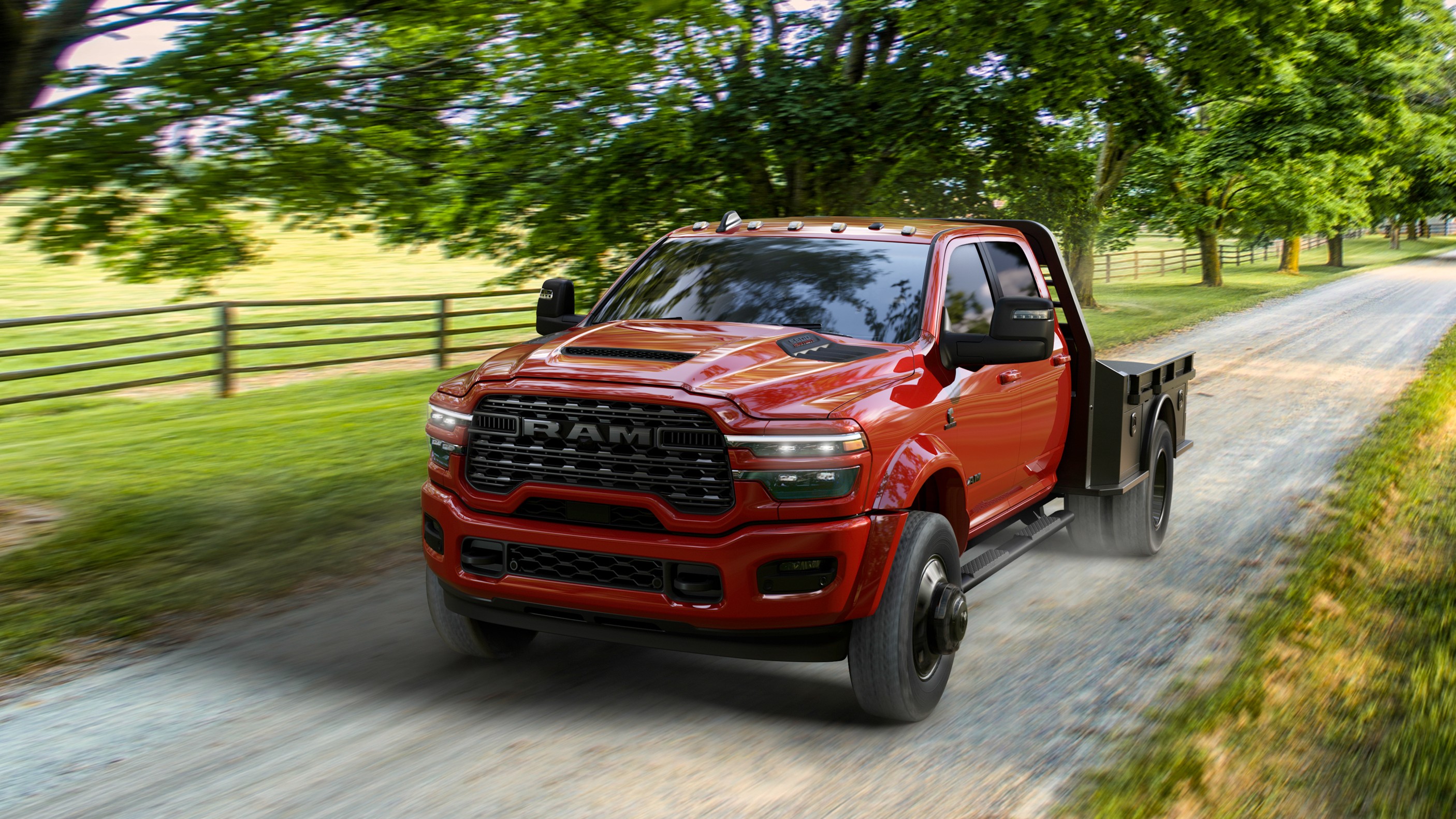 2027 Ram 3500 Chassis Cab Night Edition in red driving on a gravel road
