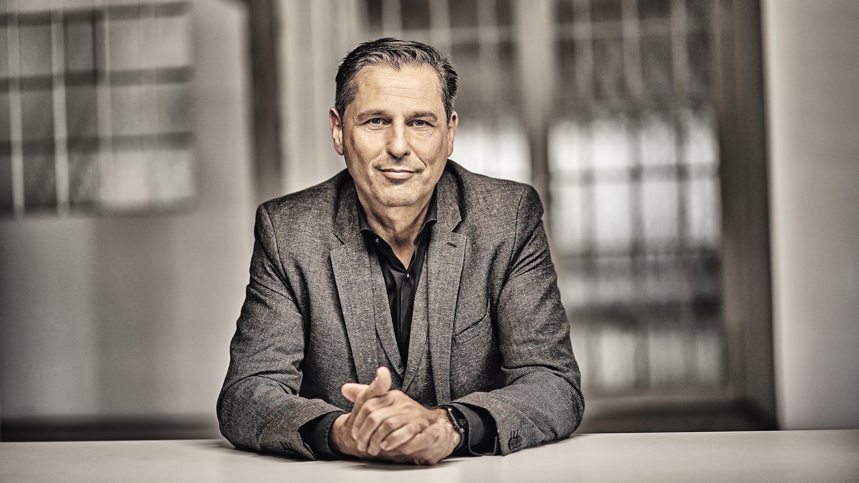 Klaus Zellmer, incoming Volvo Cars CEO, seated portrait in a gray jacket