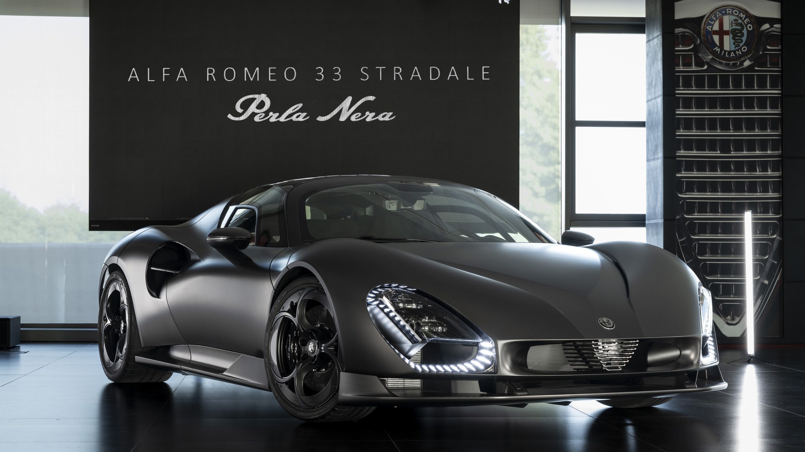 Alfa Romeo 33 Stradale Perla Nera in exposed matte carbon fiber, front three-quarter view