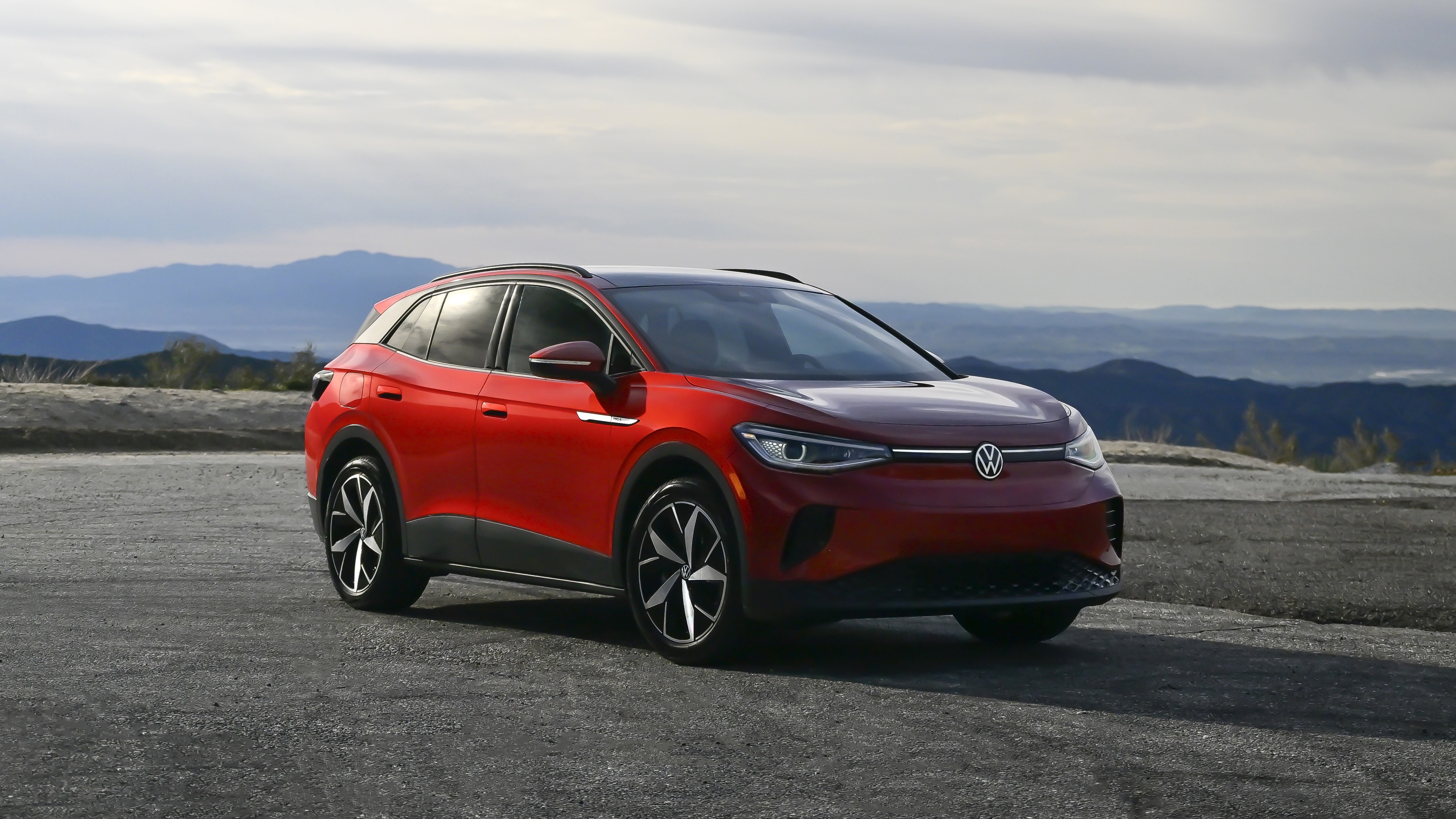 Red Volkswagen ID.4 electric SUV parked outdoors, front three-quarter view