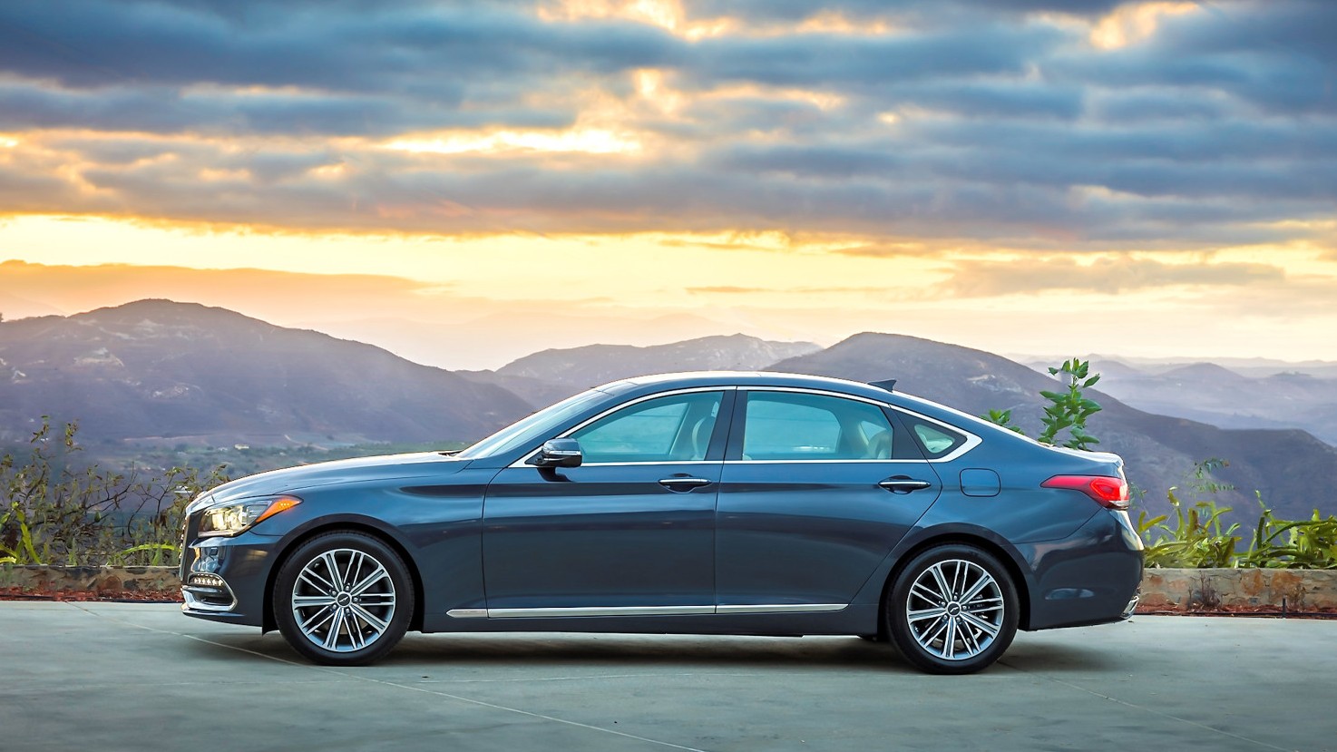 First-generation Genesis G80 sedan in profile at sunset