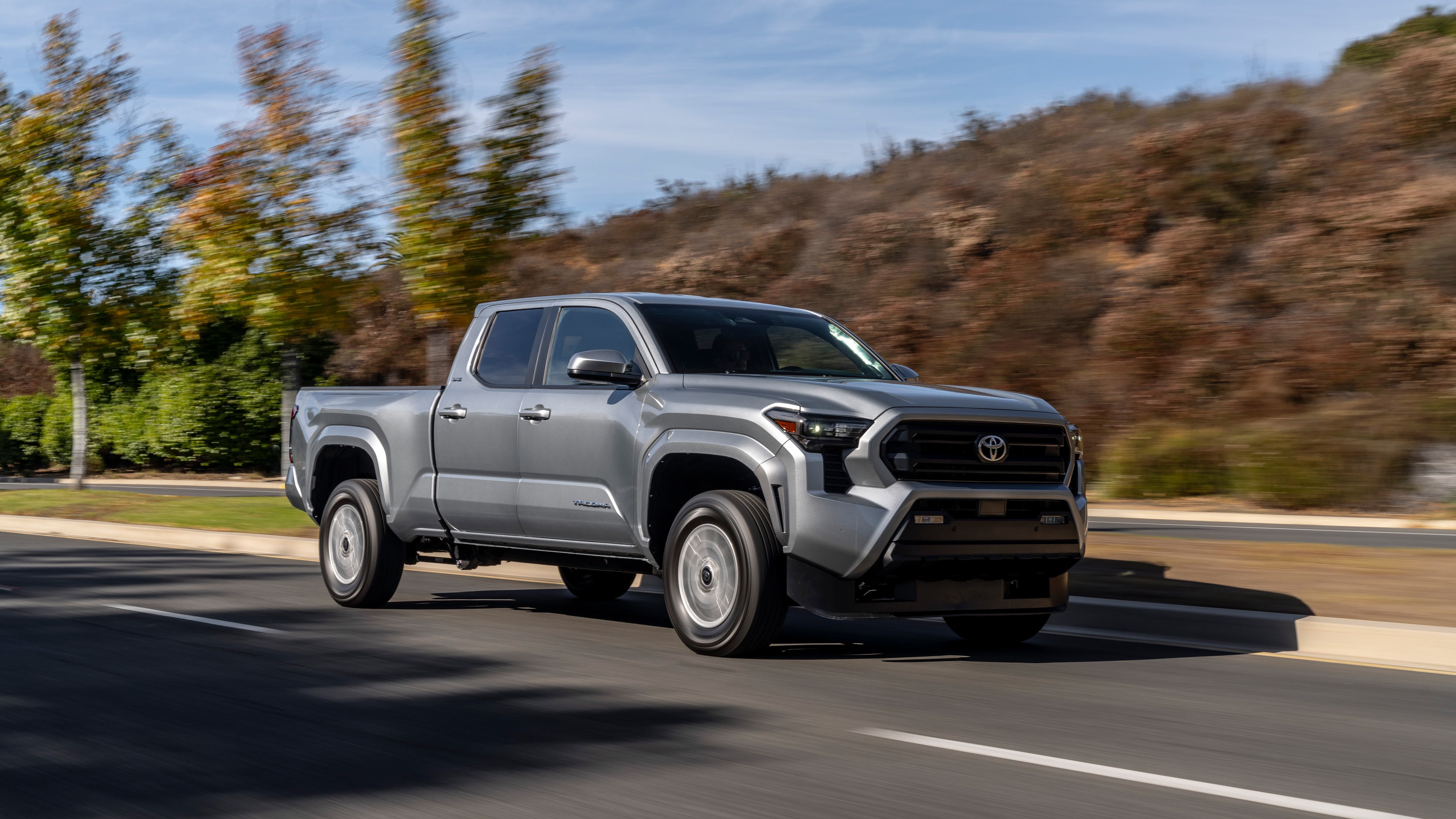 Silver 2026 Toyota Tacoma SR5 driving on a suburban road