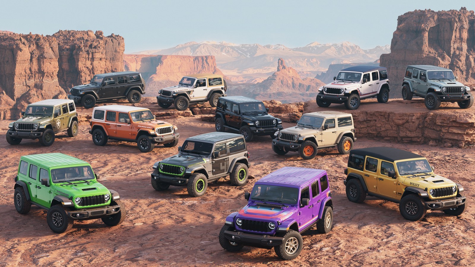A dozen Jeep Wranglers in different paint colors on red desert rock