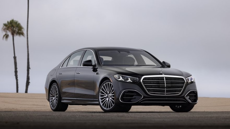 Black Mercedes-Benz S-Class sedan parked near palm trees, front three-quarter view