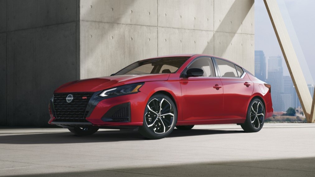 2027 Nissan Altima SR in red, front three-quarter view by a concrete wall