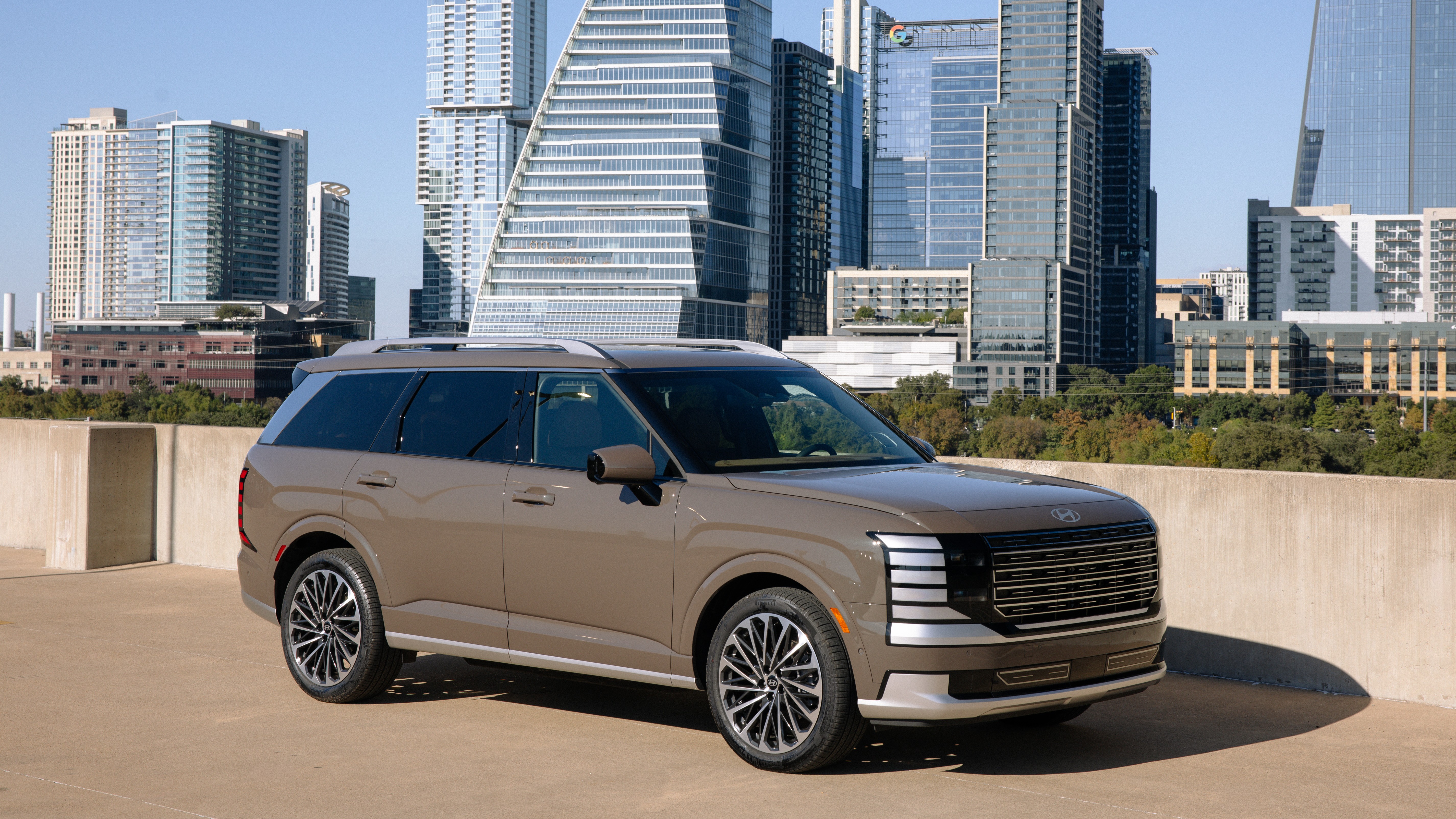 2026 Hyundai Palisade Hybrid Calligraphy front three-quarter view with city skyline