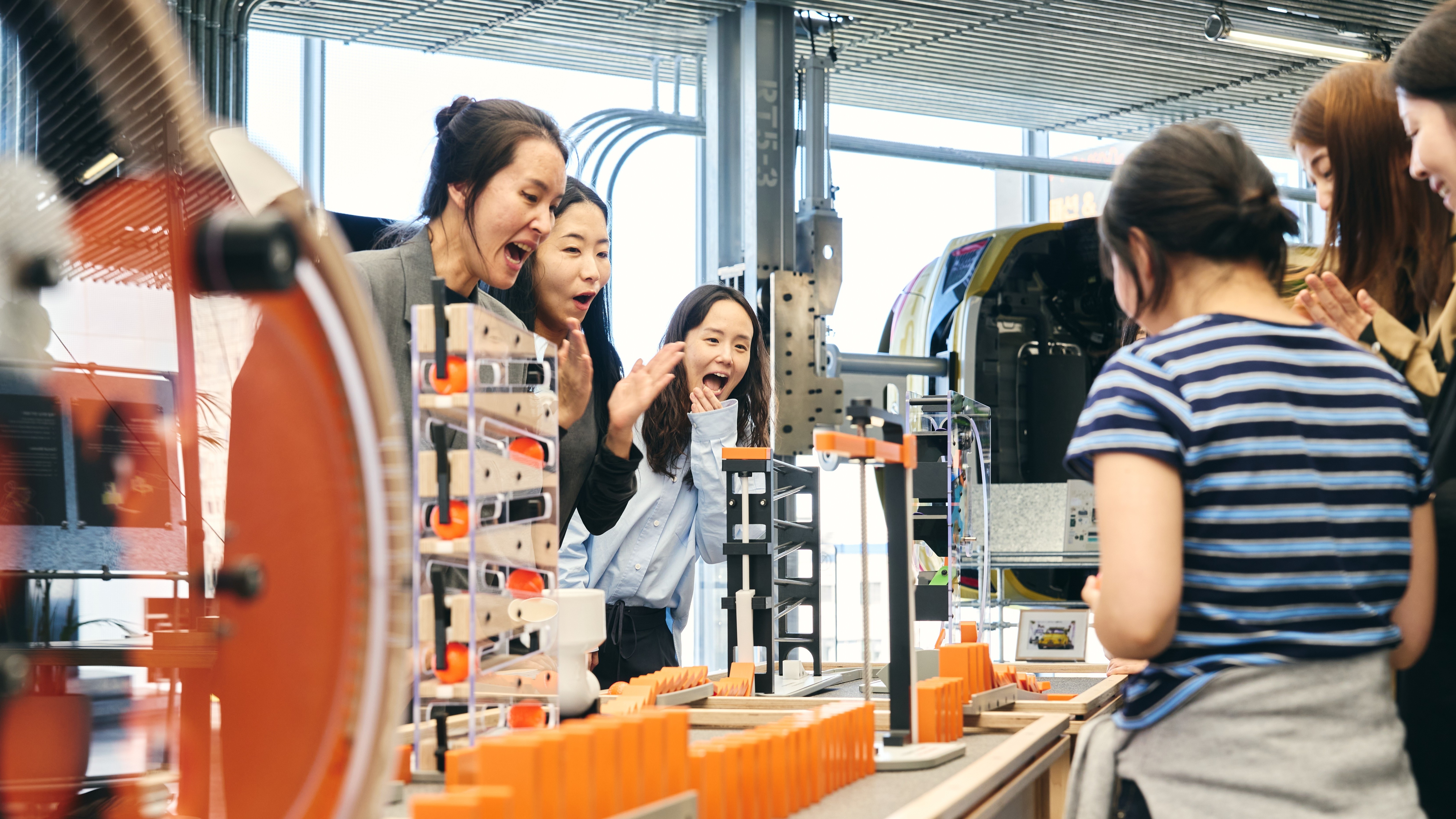 Visitors react to a domino chain-reaction exhibit at Hyundai Motorstudio Seoul