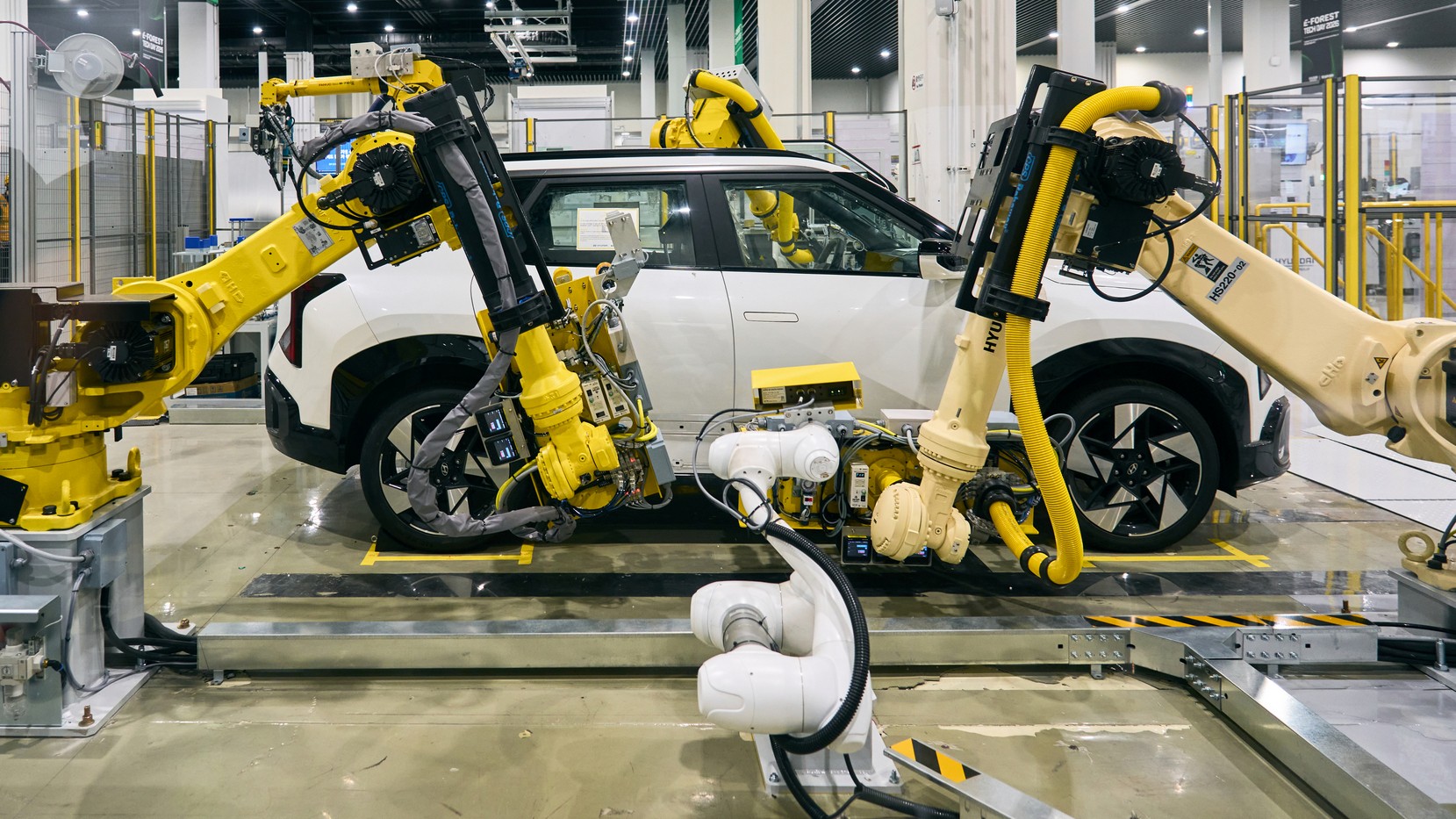 Robot arms work on a white Hyundai SUV at E-FOREST TECH DAY 2026