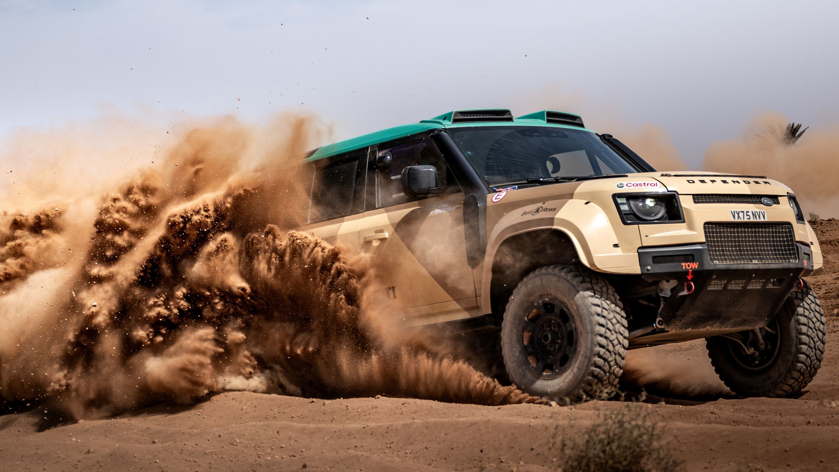 Defender Dakar D7X-R rally car kicking up sand in Morocco