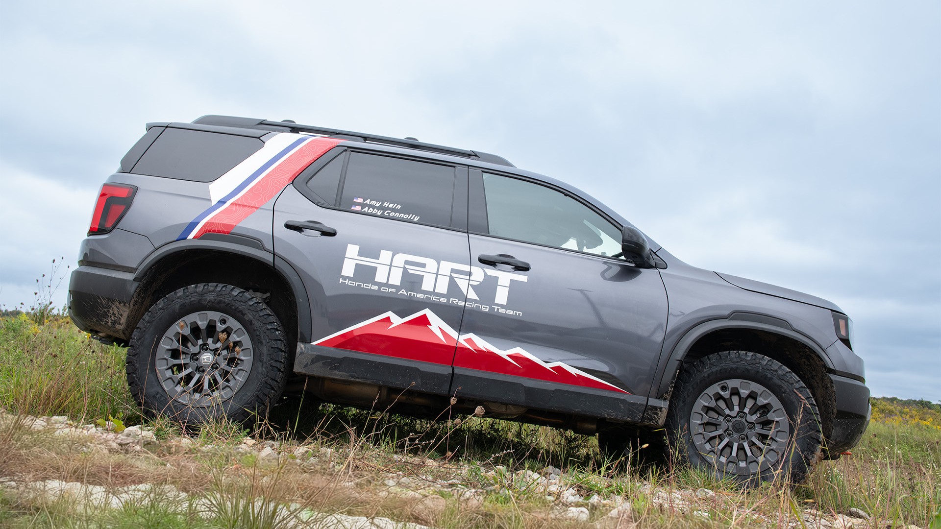 Honda Passport TrailSport in HART Rebelle Rally livery on a rocky slope
