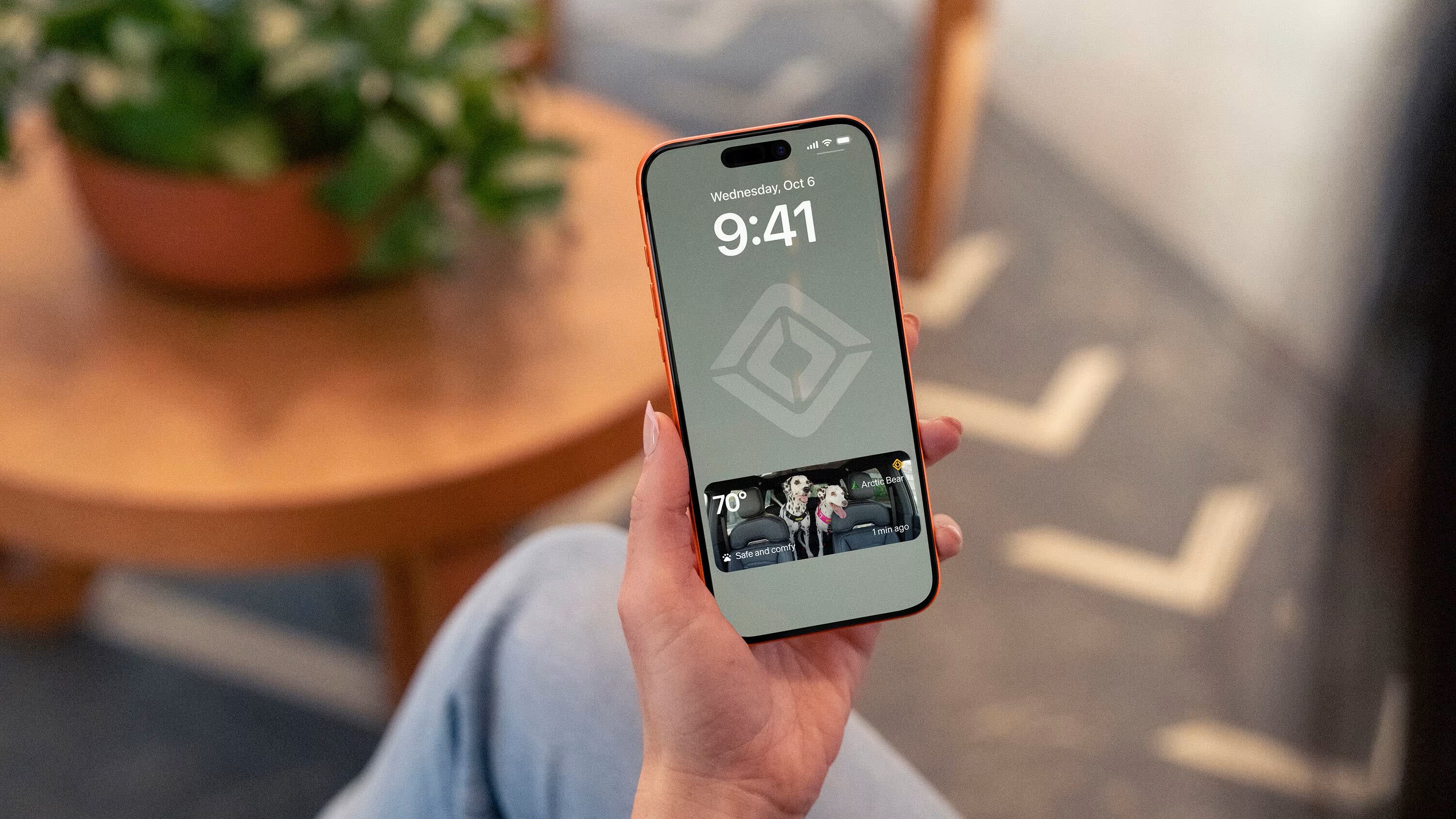Phone lock screen showing a Rivian Pet Cam snapshot of two Dalmatians
