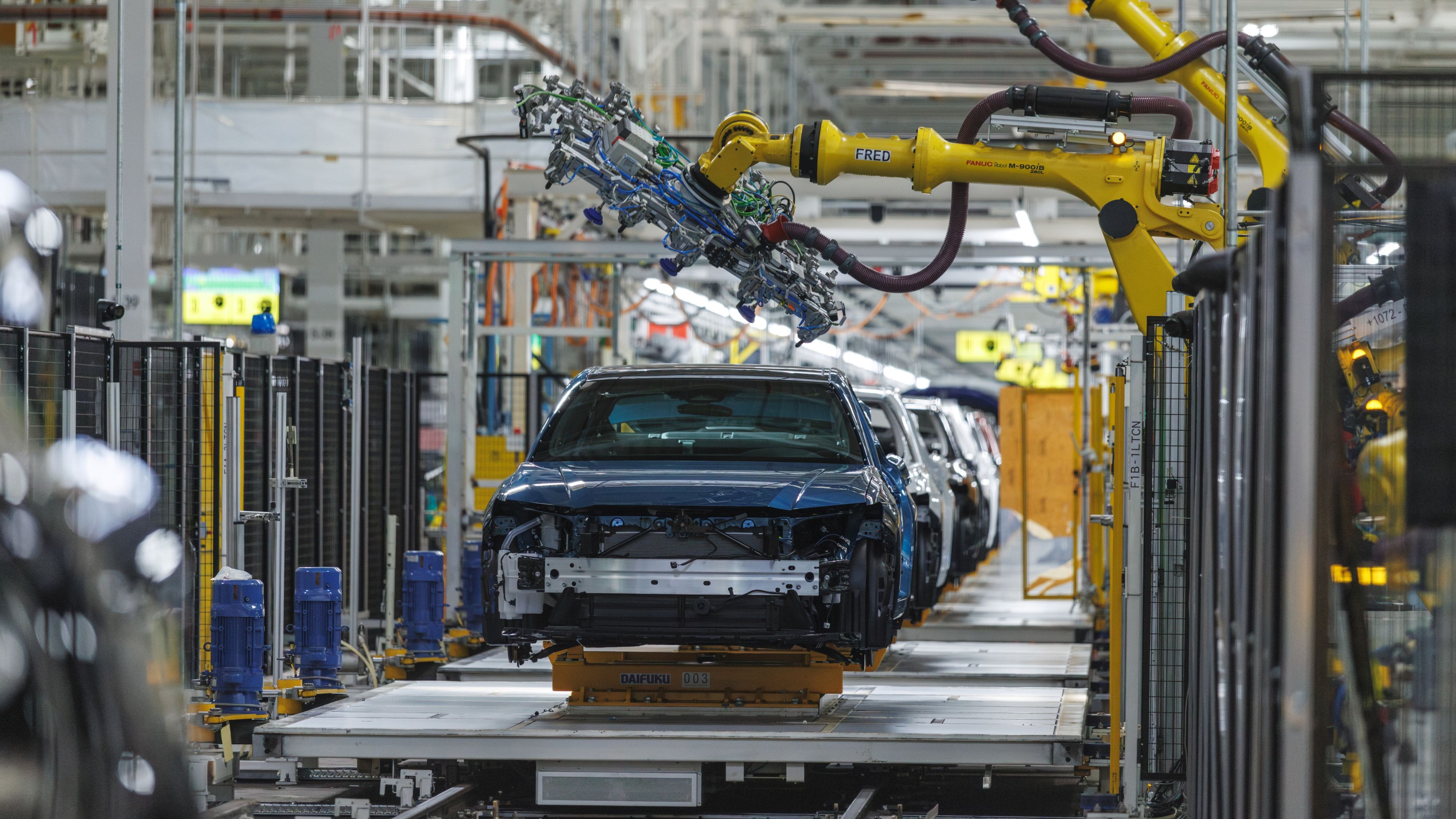 “Sedan body on the assembly line beneath yellow robot arms at Toyota Kentucky