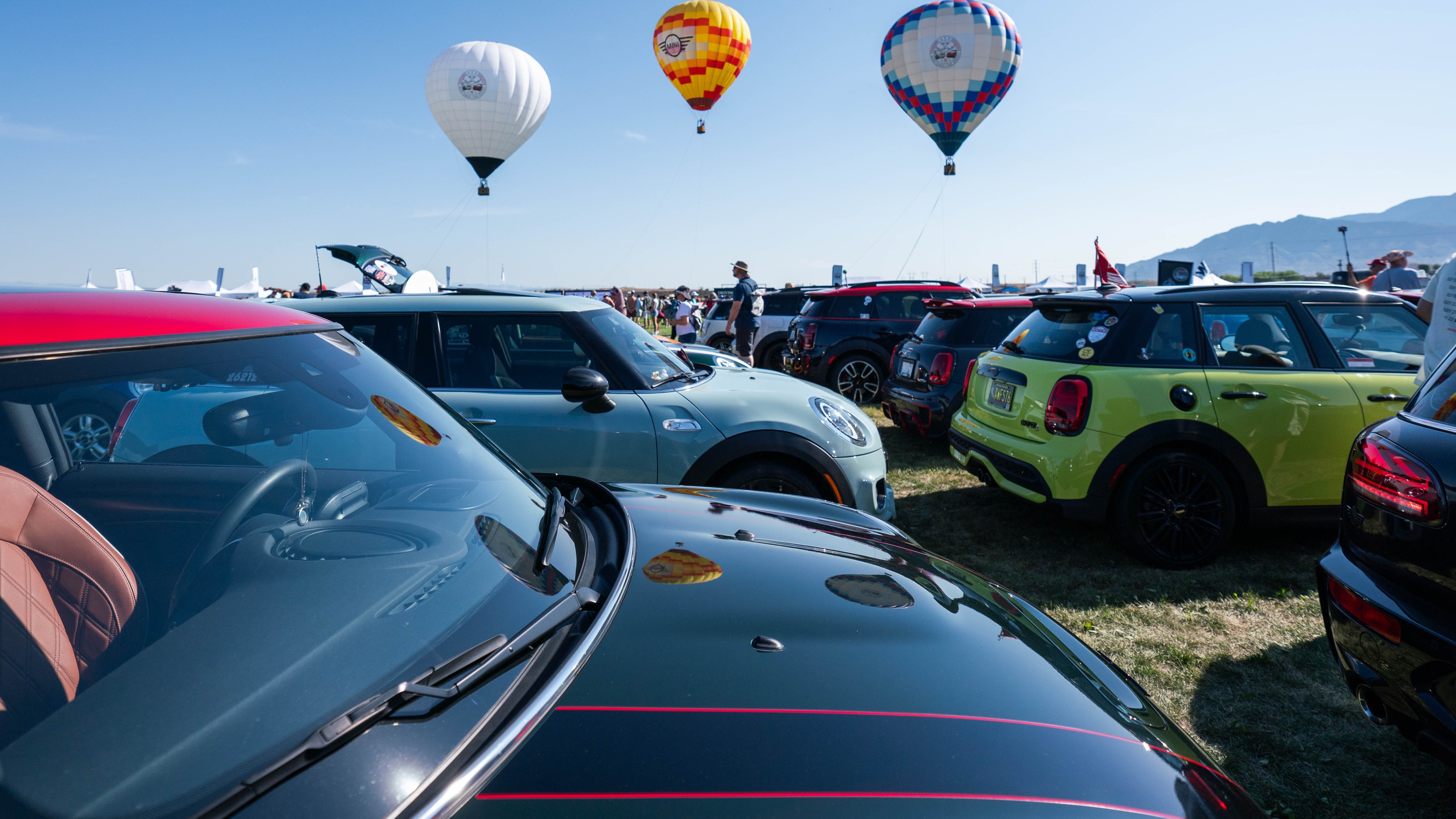 Rows of MINI cars beneath tethered hot-air balloons at the 2024 rally