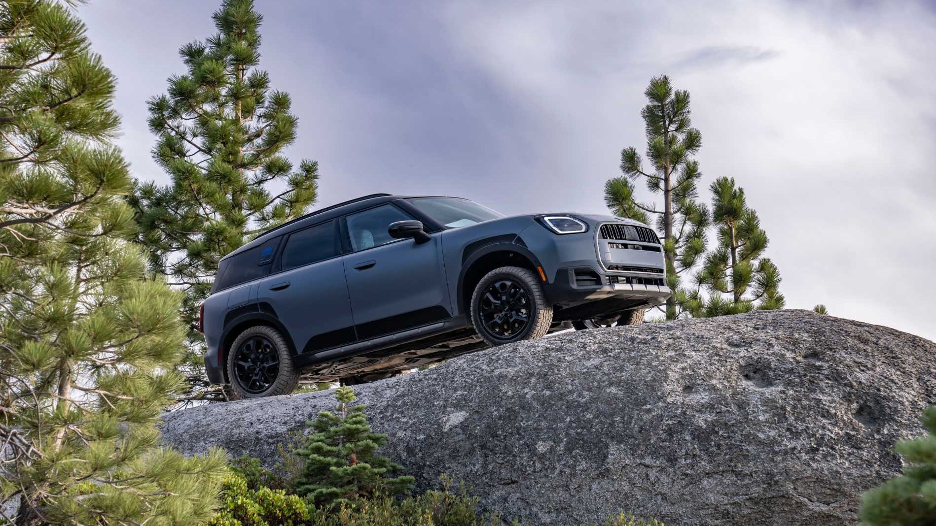 MINI Countryman Untamed Edition climbing a granite boulder in a pine forest