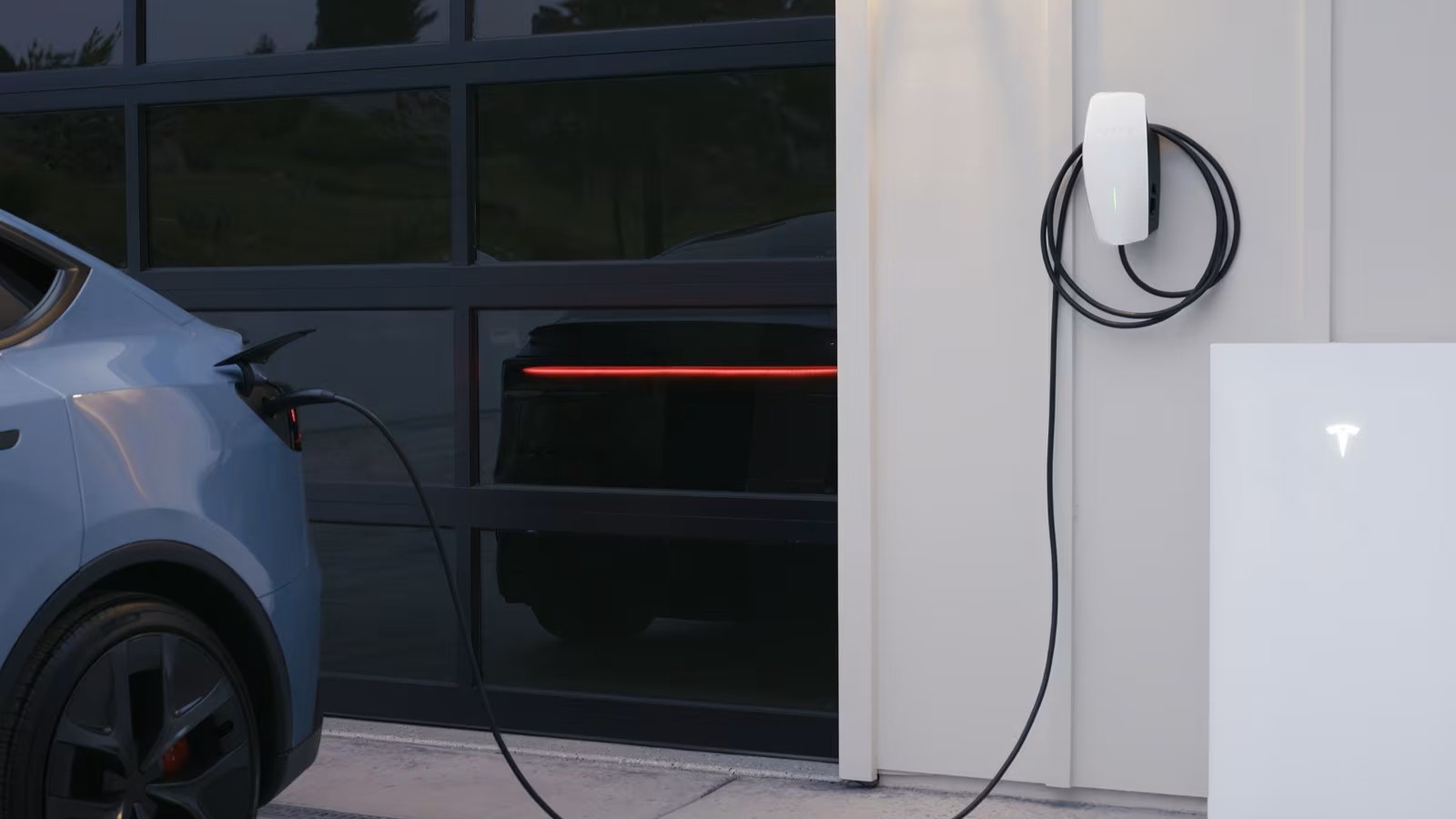 Tesla Model Y plugged into a Wall Connector next to a Powerwall