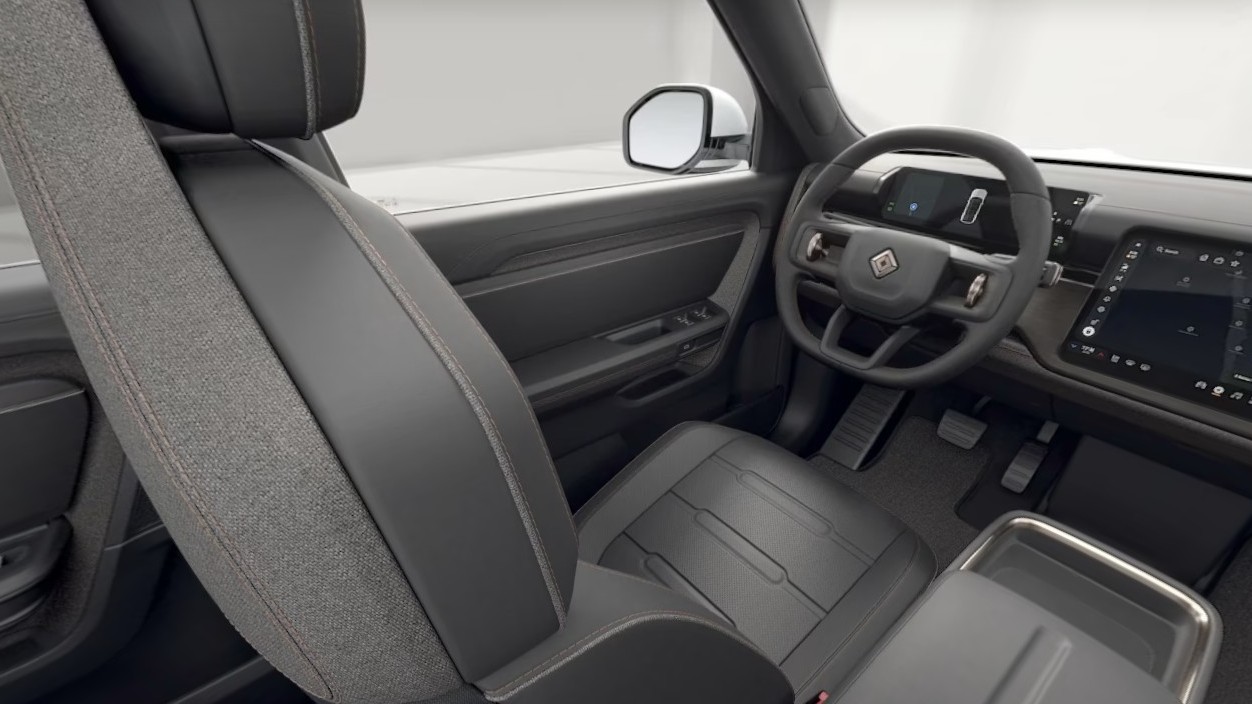 Rivian R2 interior render showing the front seats, steering wheel and center display