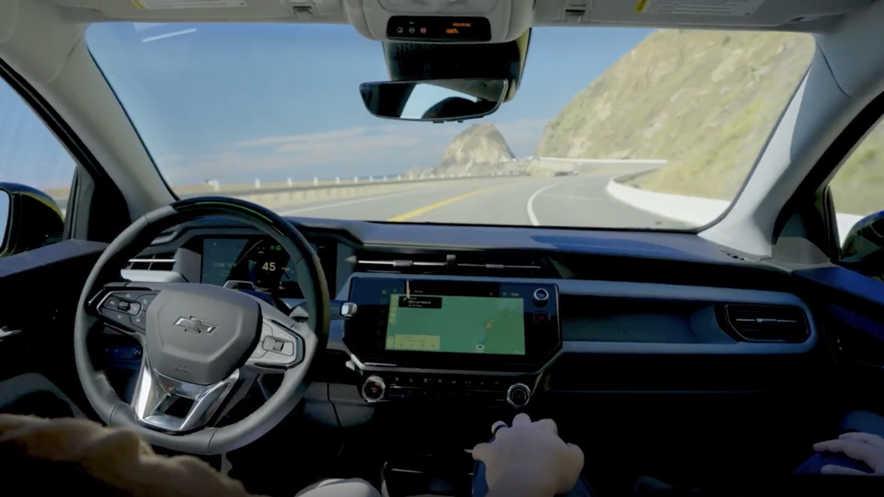 Driver using GM Super Cruise hands-free on a coastal highway
