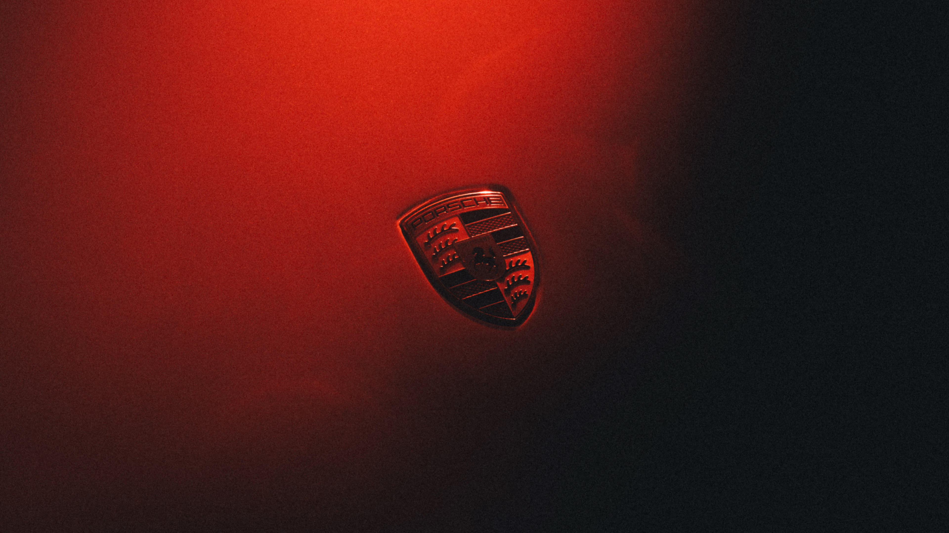 Porsche crest on a red body panel in the Mission S teaser