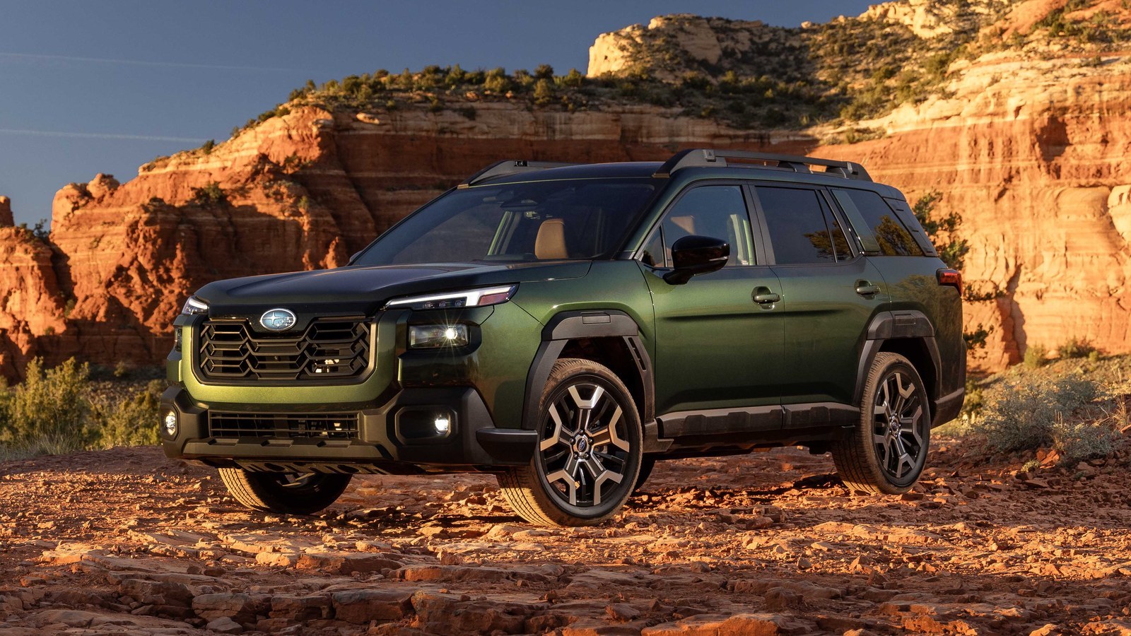 Green Subaru Outback Wilderness parked on red rock trail