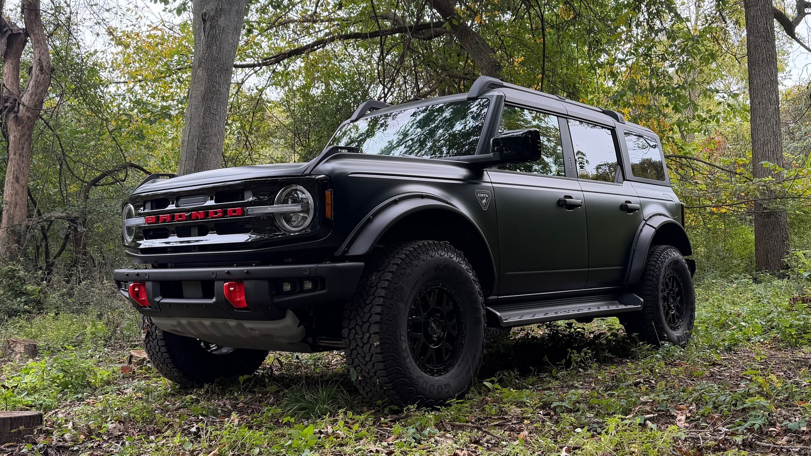 Matte black four-door Ford Bronco with the ORV Package in the woods