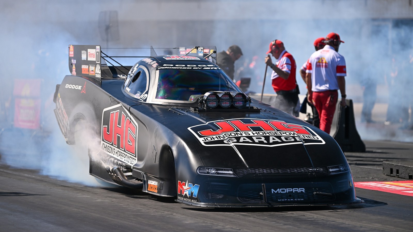 Matt Hagan's black Dodge Charger SRT Hellcat Funny Car in a burnout