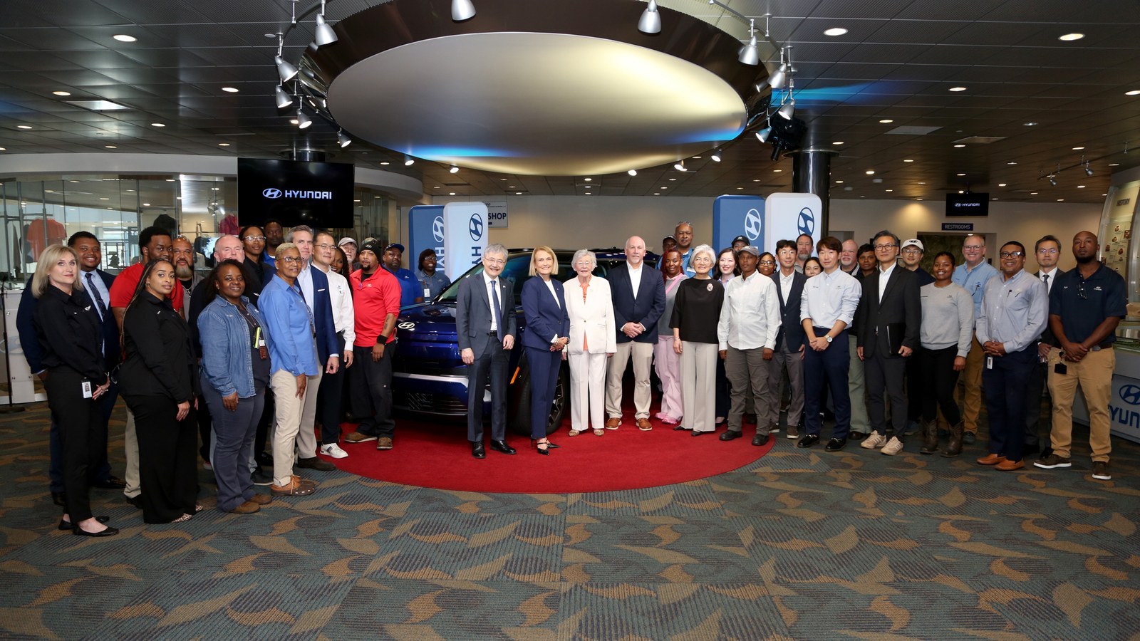 Officials and Hyundai workers pose with an SUV at the Montgomery plant