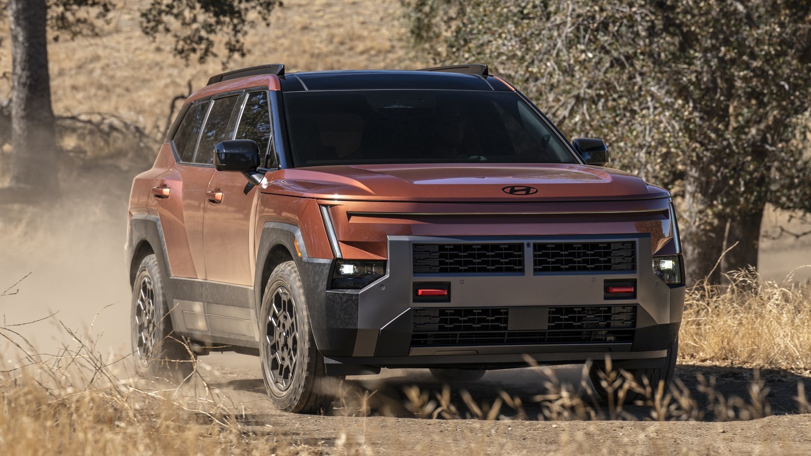 Orange 2027 Hyundai Tucson XRT PRO driving on a dirt trail