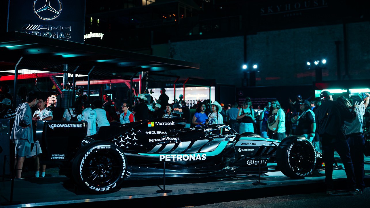 Mercedes F1 show car surrounded by fans at a night fan event