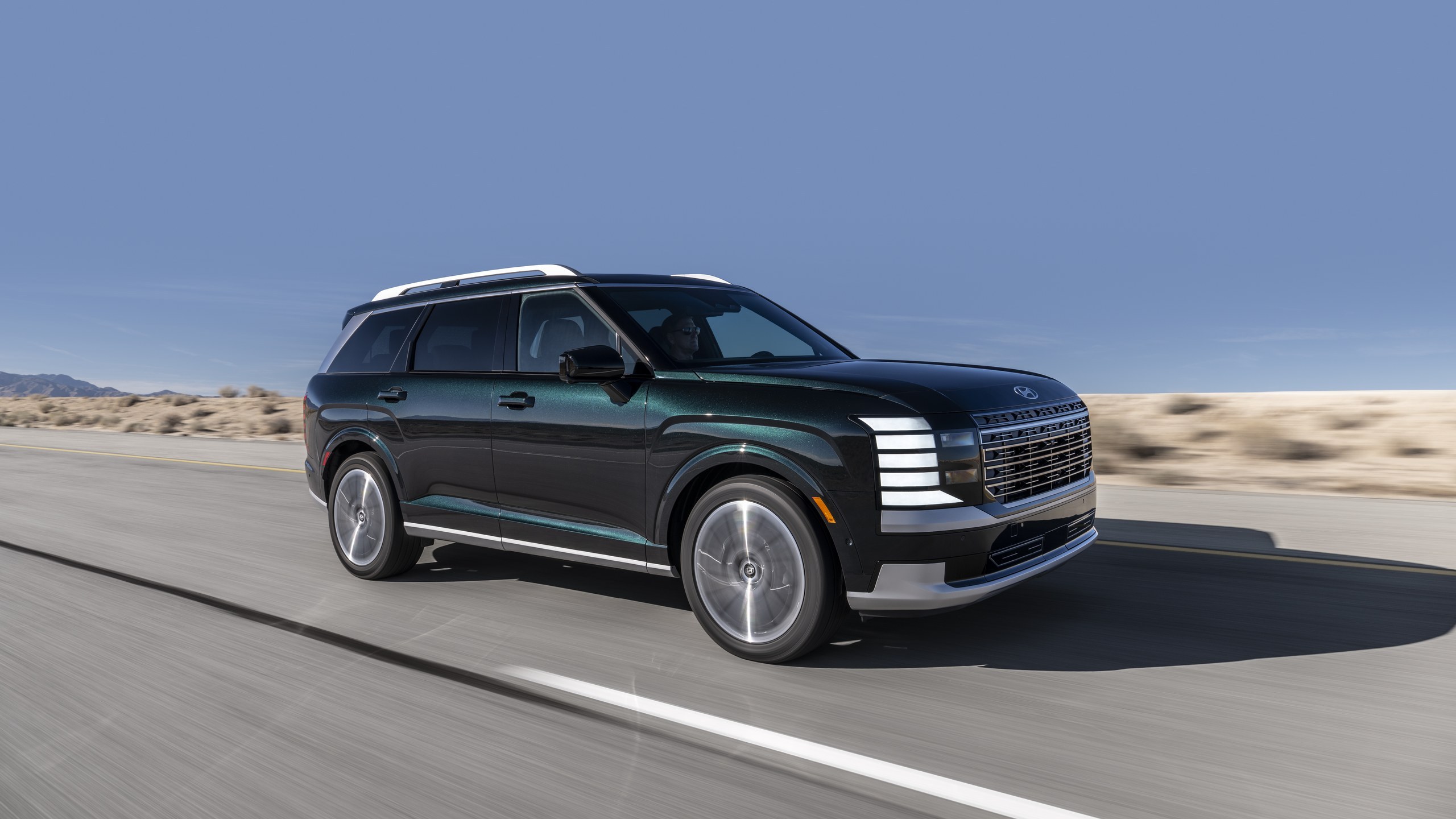 Black 2027 Hyundai Palisade Hybrid driving on a desert highway