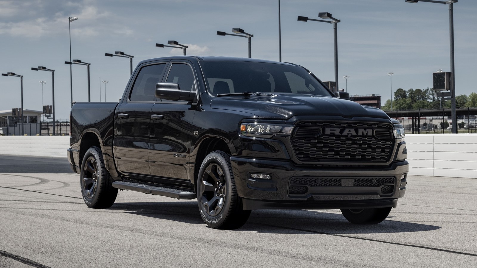 Black 2026 Ram 1500 pickup parked on a racetrack apron